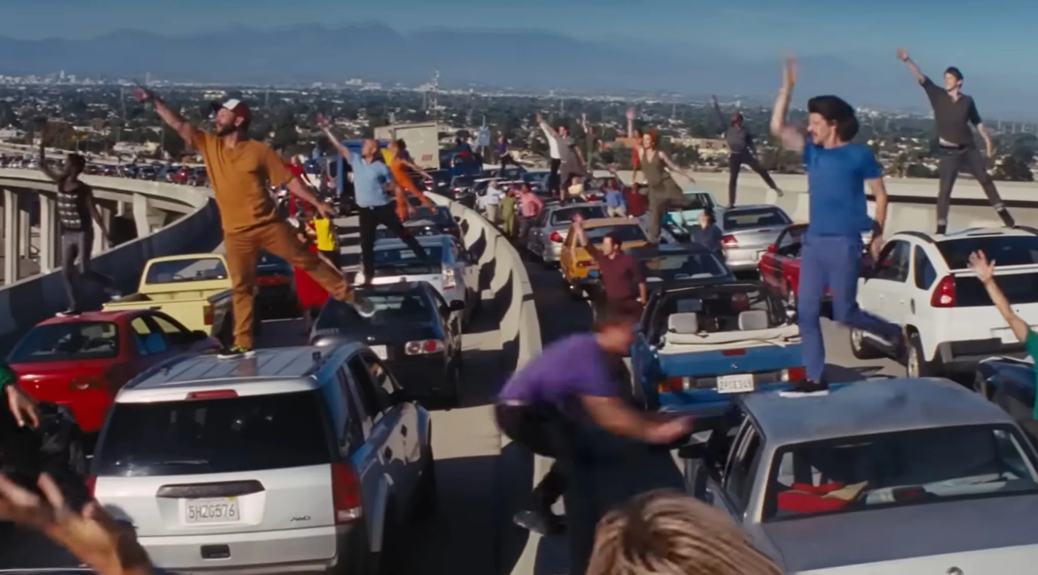Drivers stuck in a Los Angeles traffic jam burst into a synchronized song-and-dance in this opening movie scene.