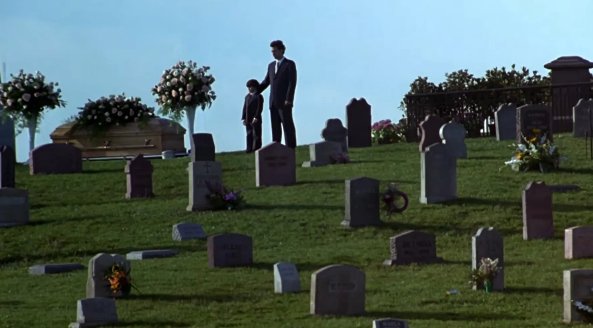 Sleepless in Seattle opening movie scene: A man and his young son at a gloomy cemetery for a funeral.