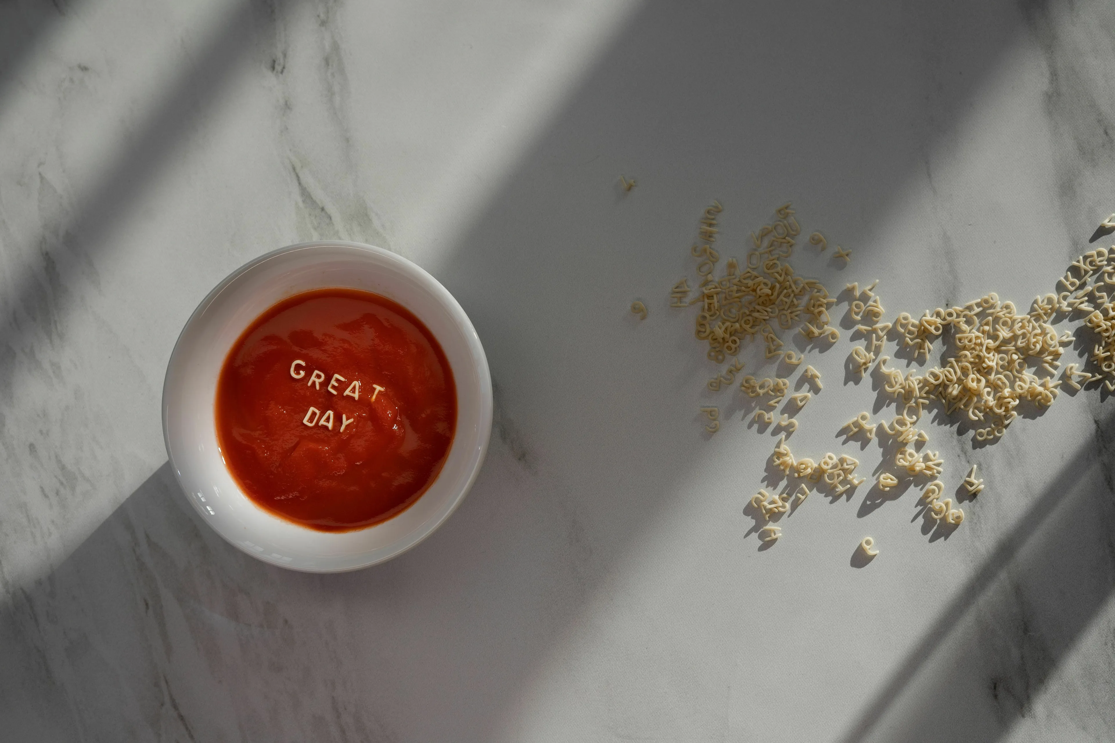 A bowl of soup with alphabet pasta spelling 'GREAT DAY', illustrating a perfect day for an extinct species.