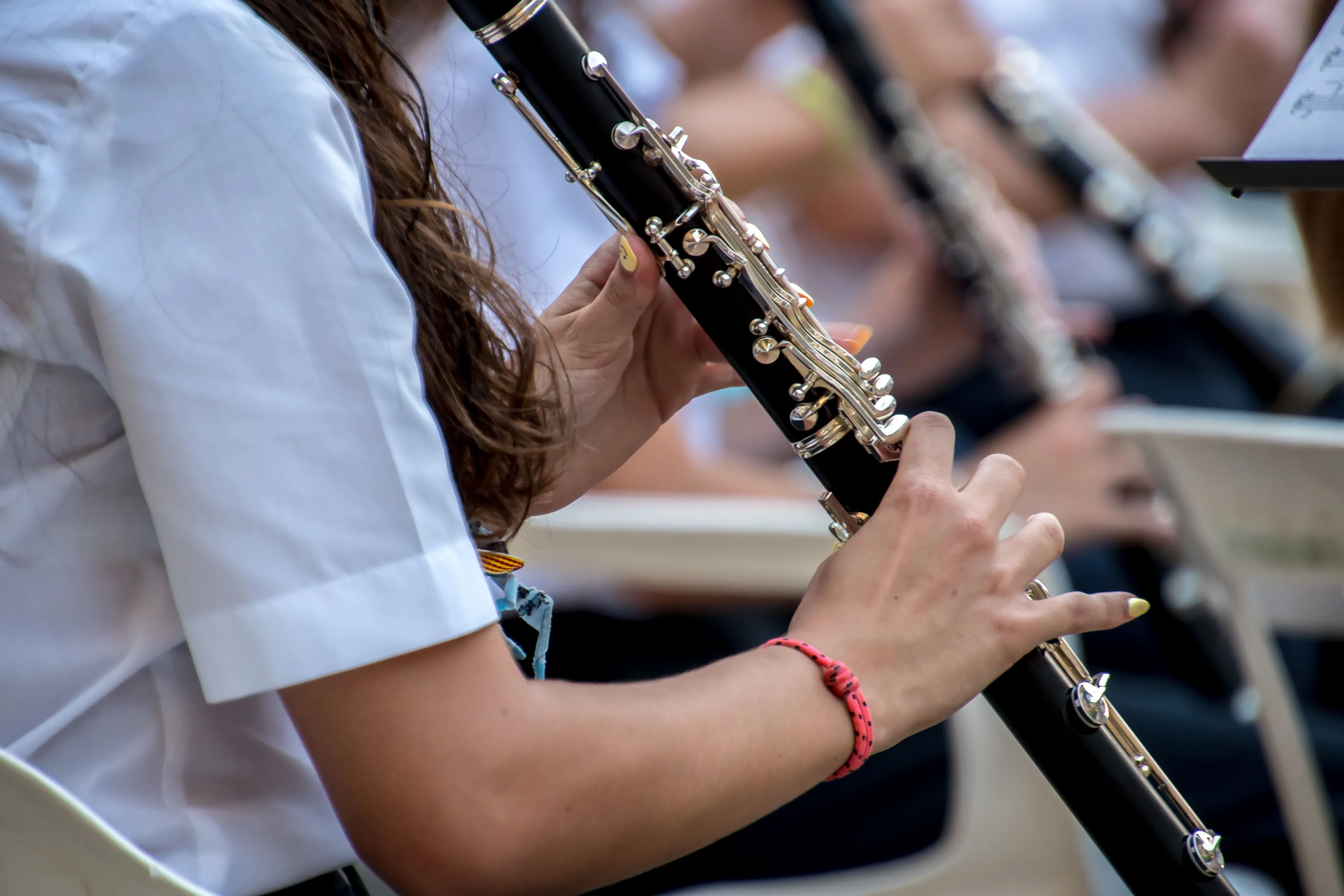 A person playing a Clarinet instrument, part of the woodwind family, for a music quiz question.