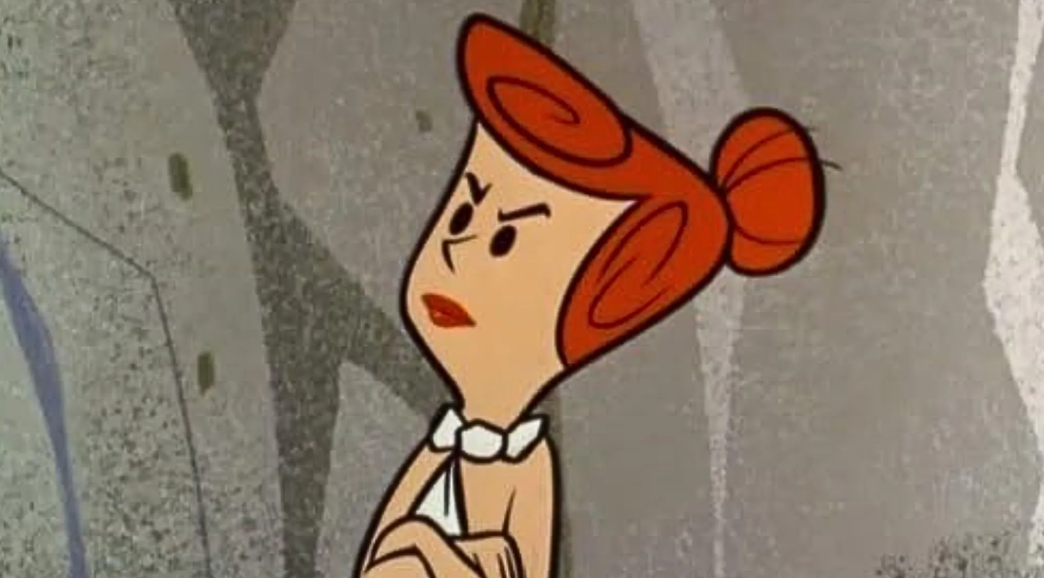 A Saturday Morning Cartoon Trivia character, Wilma Flintstone, with her arms crossed looking angry.