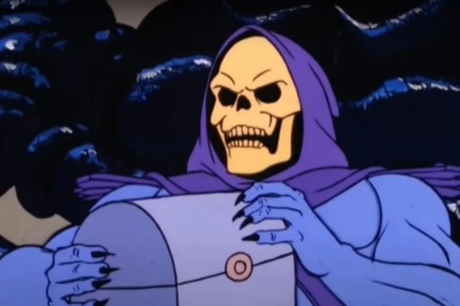 Skeletor, the primary nemesis of He-Man, in a purple hood, holding a large grey object.