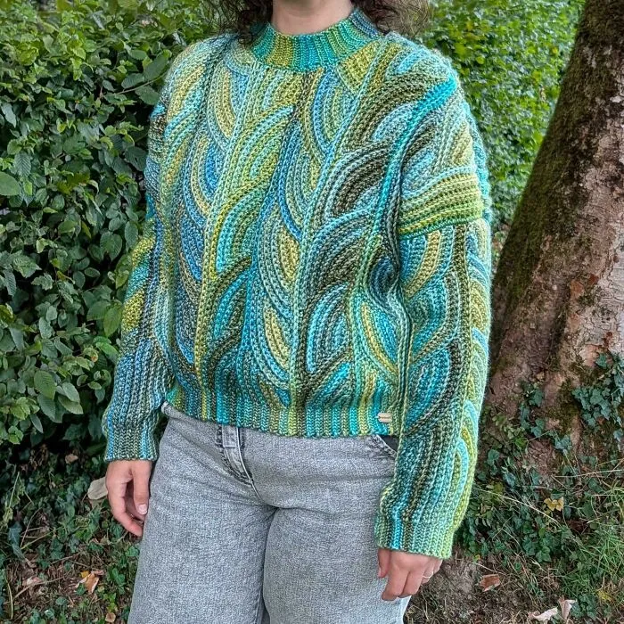 Person wearing blue and green multicolor crochet sweater outdoors