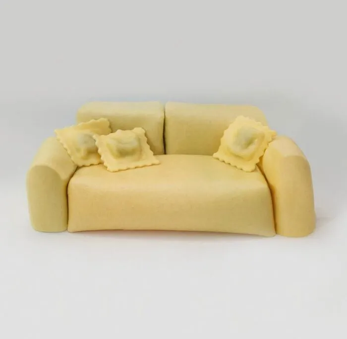A miniature couch made of pasta with ravioli cushions, highlighting bizarre furniture design.
