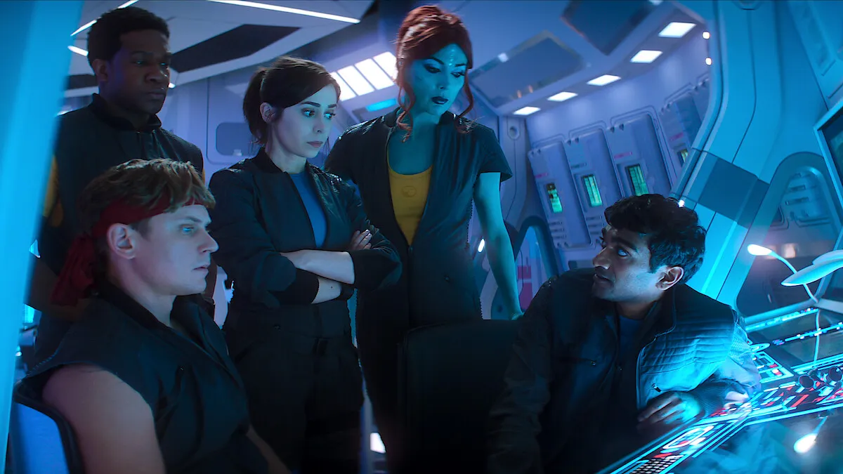 Characters from the TV show Black Mirror in a futuristic spaceship cockpit.