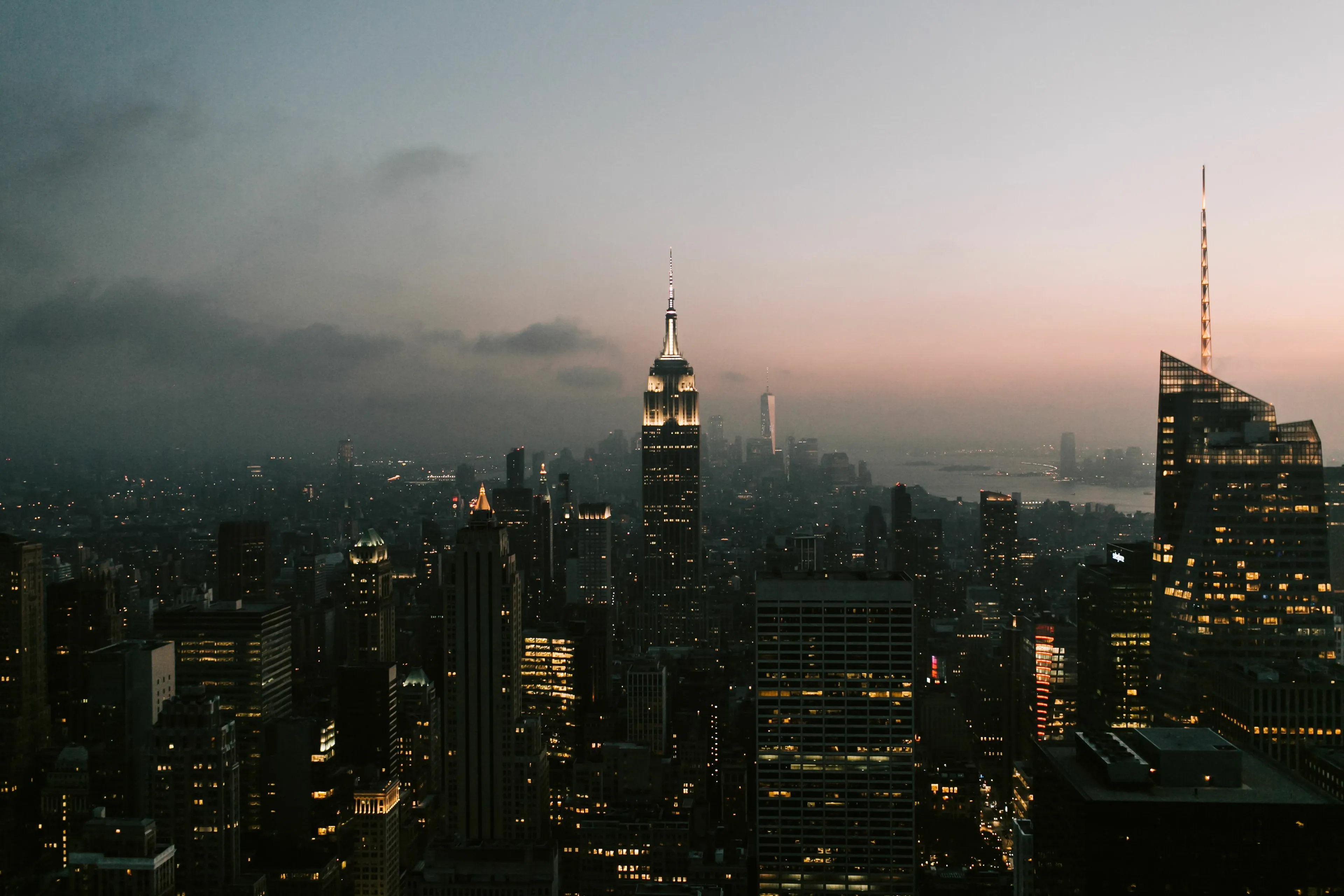 An evening cityscape of New York with the Empire State Building illuminated, a classic urban vacation spot.