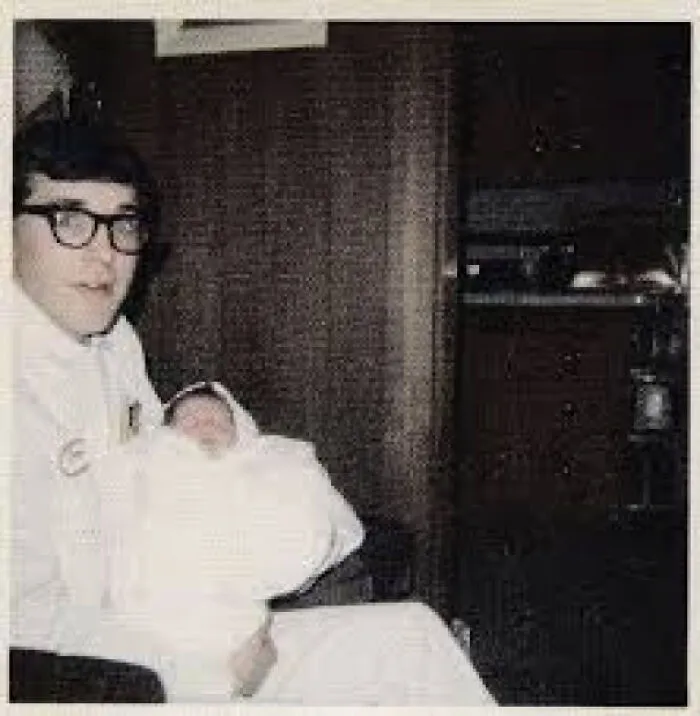 A person holding a baby, a personal moment within history that changes our sense of timeline facts.