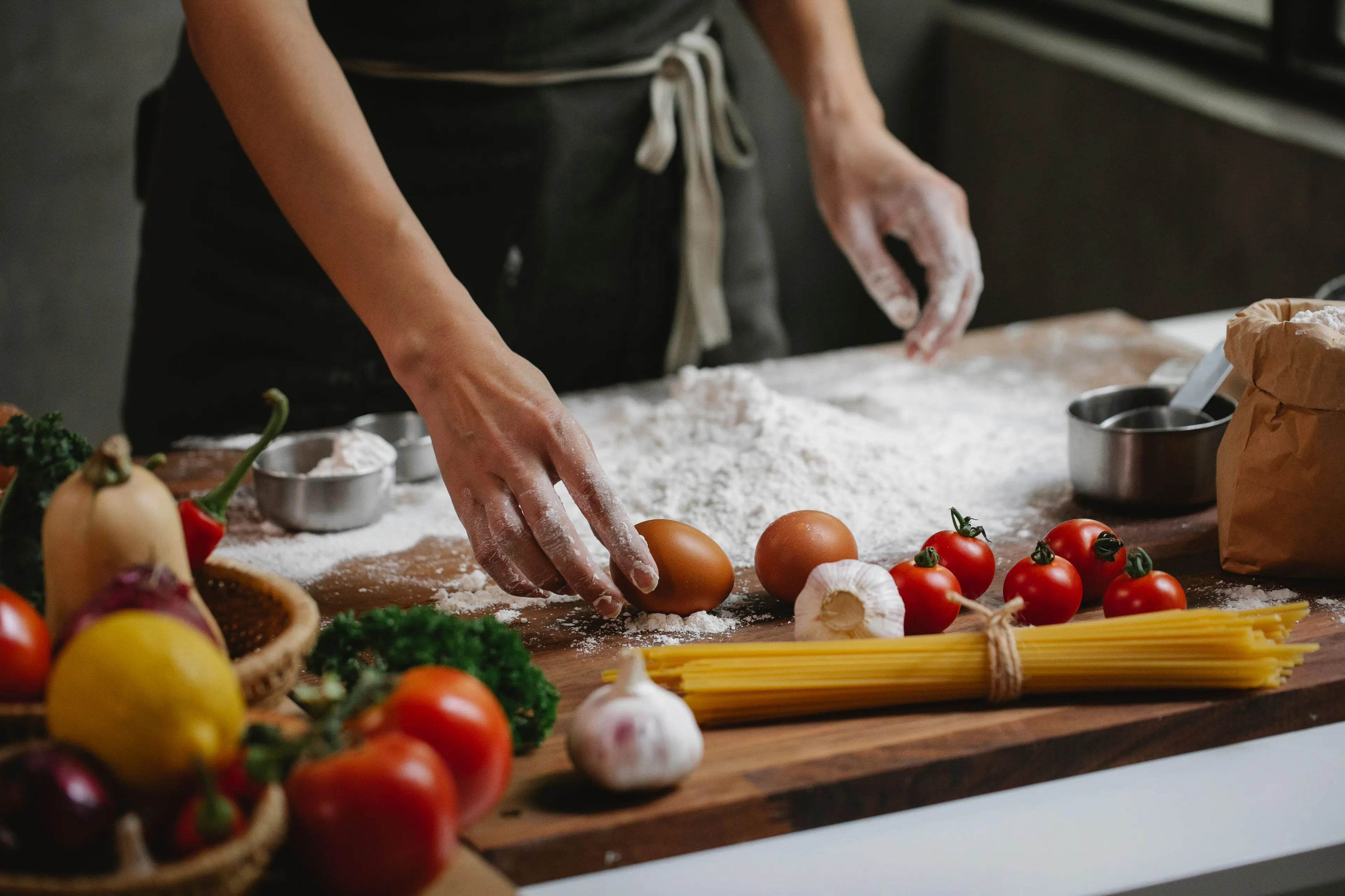 Cooking a full course meal on a rainy afternoon, hands preparing dough with fresh ingredients.