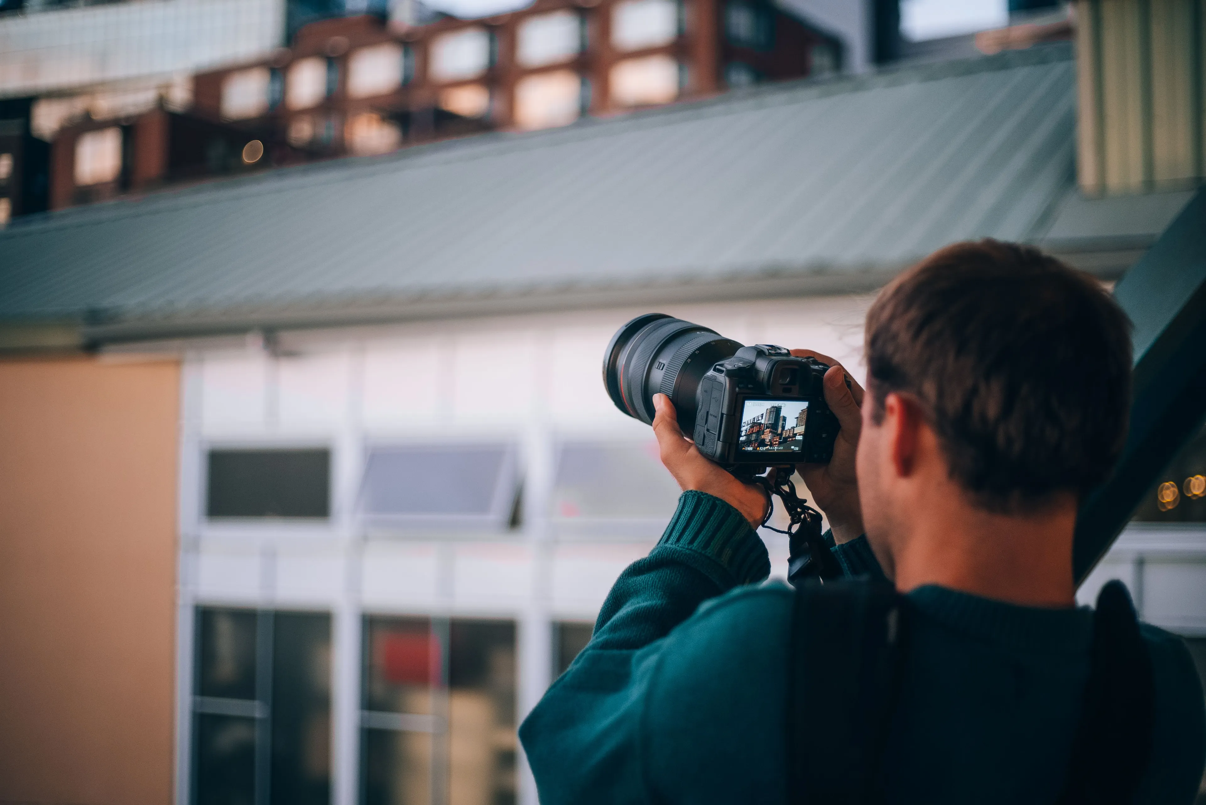 A person is holding a camera, taking a picture of the city. This photography hobby helps to master new skills.