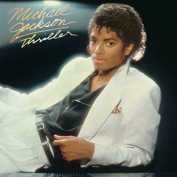 Michael Jackson on his Thriller album cover, posing in a white suit. A timeline fact about sense of history.