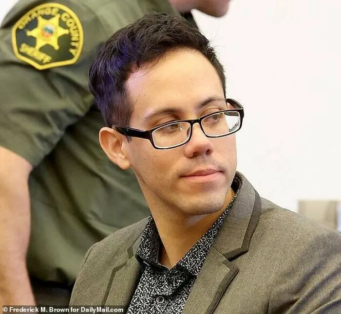 A man with glasses and a gray jacket in a courtroom, a scenario that often involves revealing timeline facts and legal history.