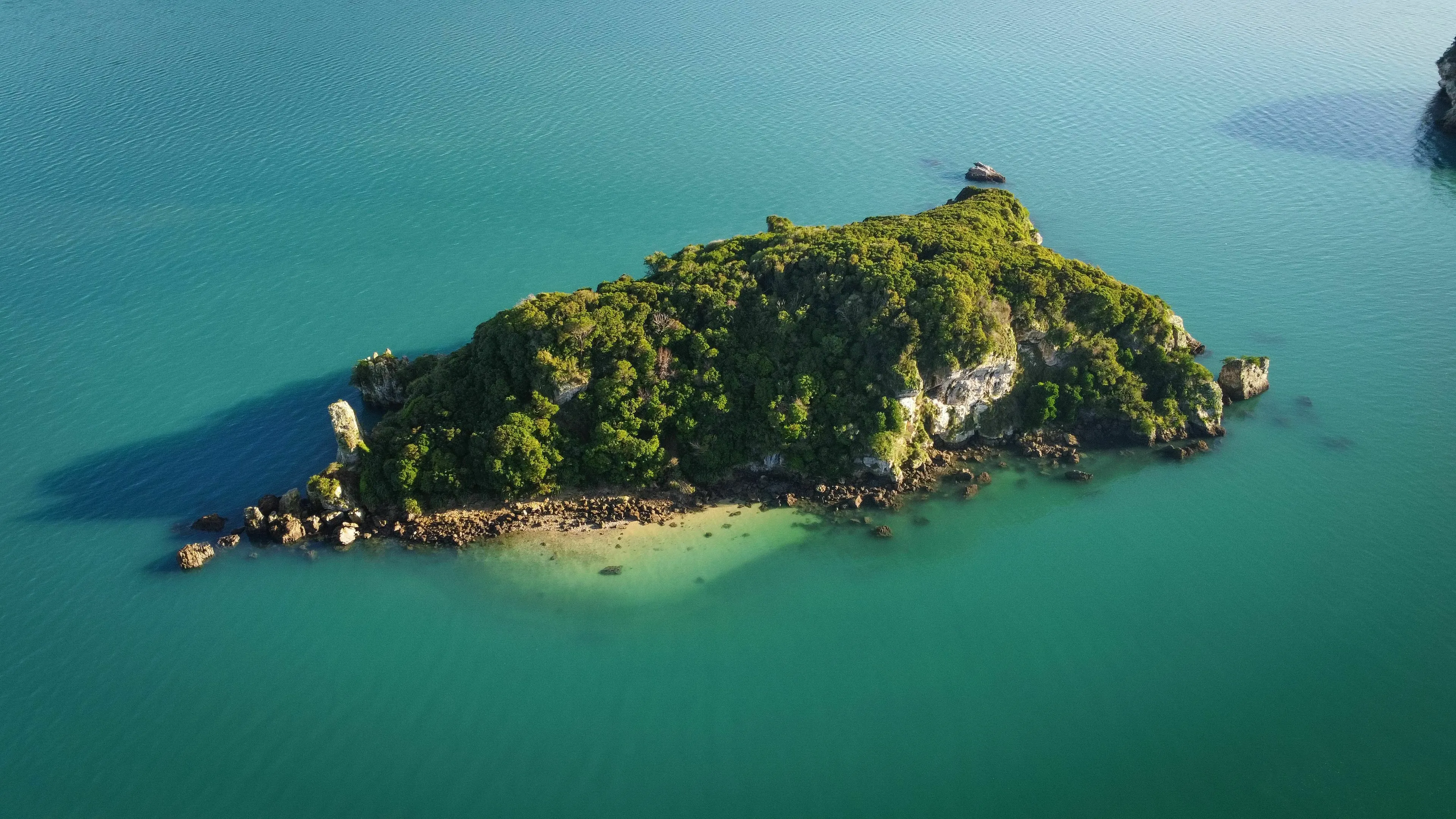 A lush green island surrounded by clear turquoise water, posing the odd one out general knowledge challenge.
