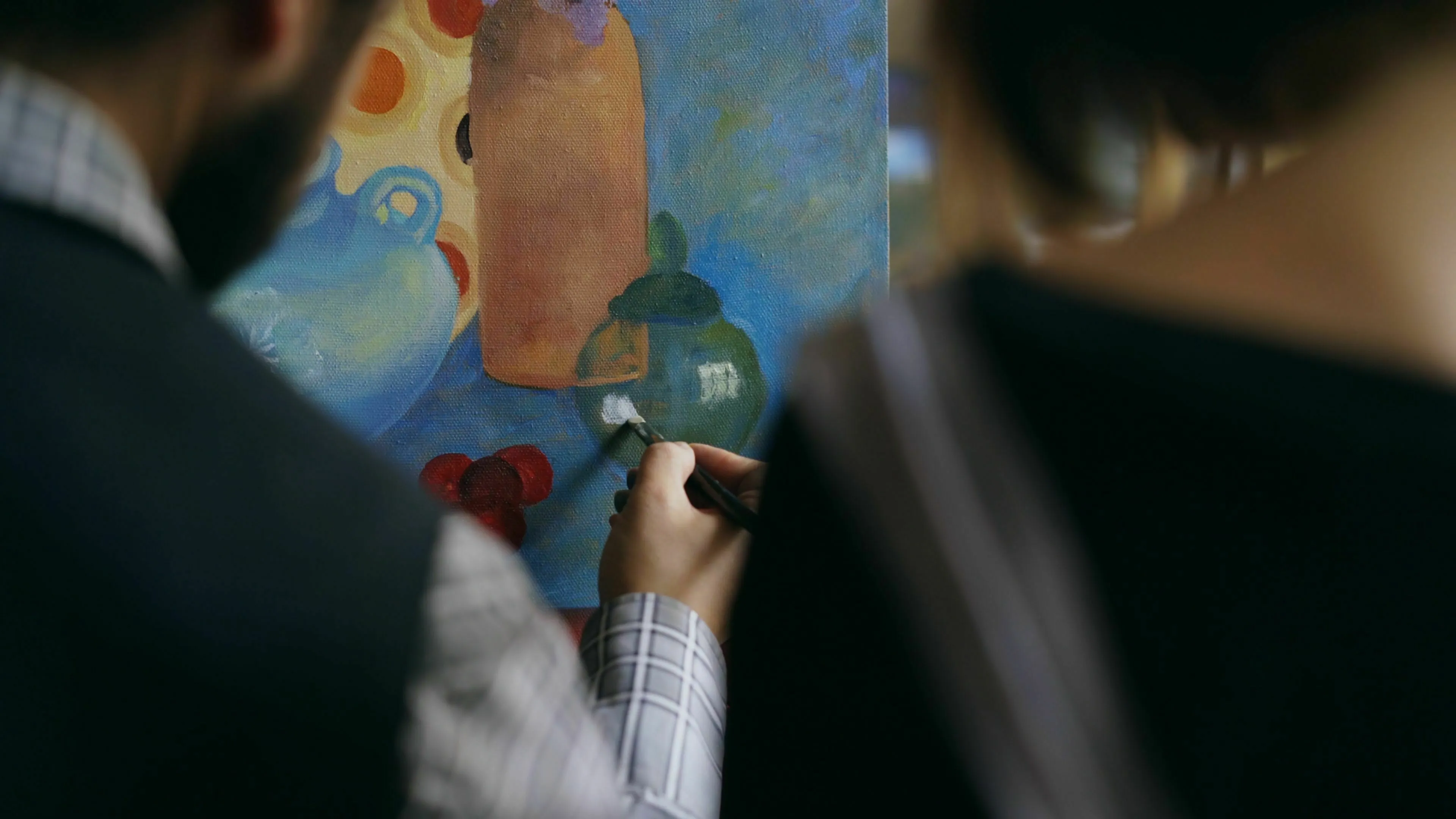 A person painting on a canvas, focused on the odd one out challenge in general knowledge.
