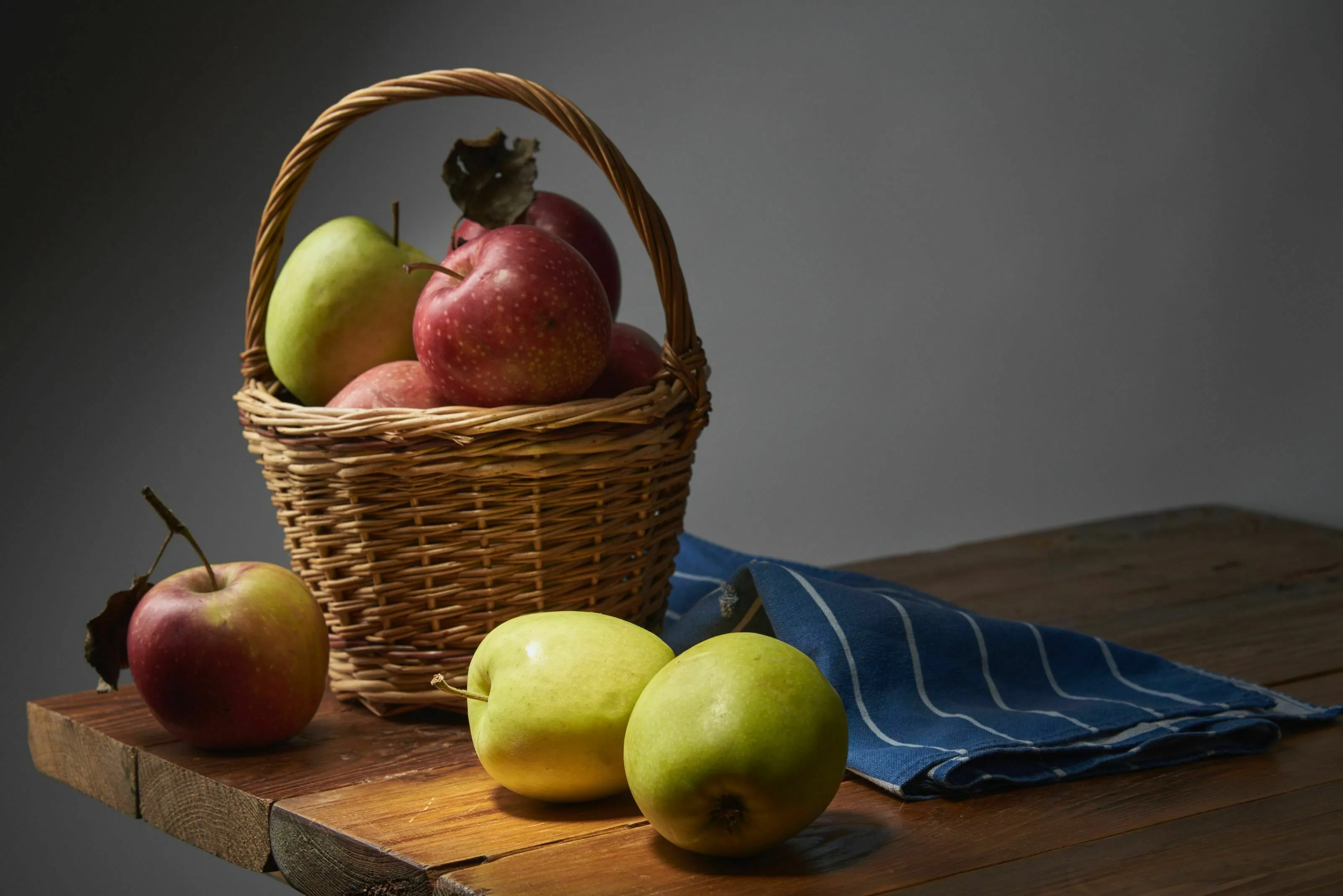 A basket of apples and loose apples on a table, representing a tricky question about fruit.