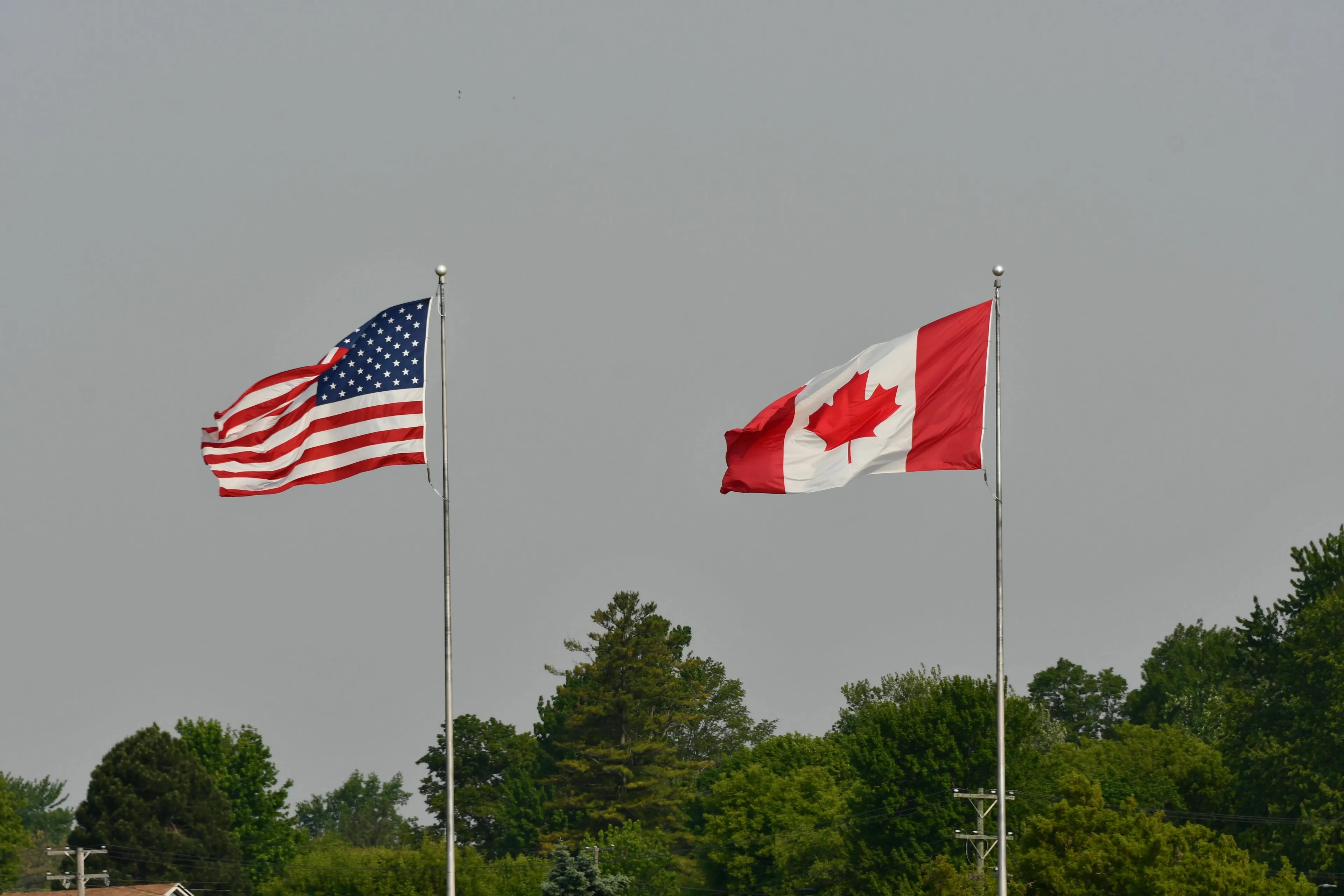 US and Canada flags flying high, representing the border crash question for tricky questions.