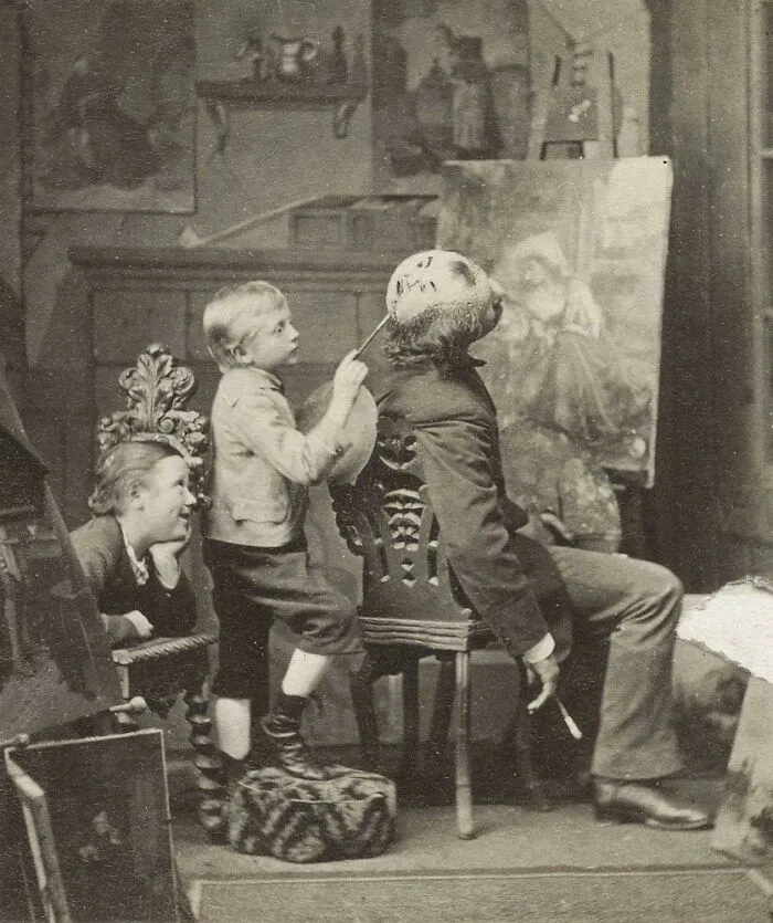 Historical photos: Two children painting an adult's head, an endearing scene from the past.
