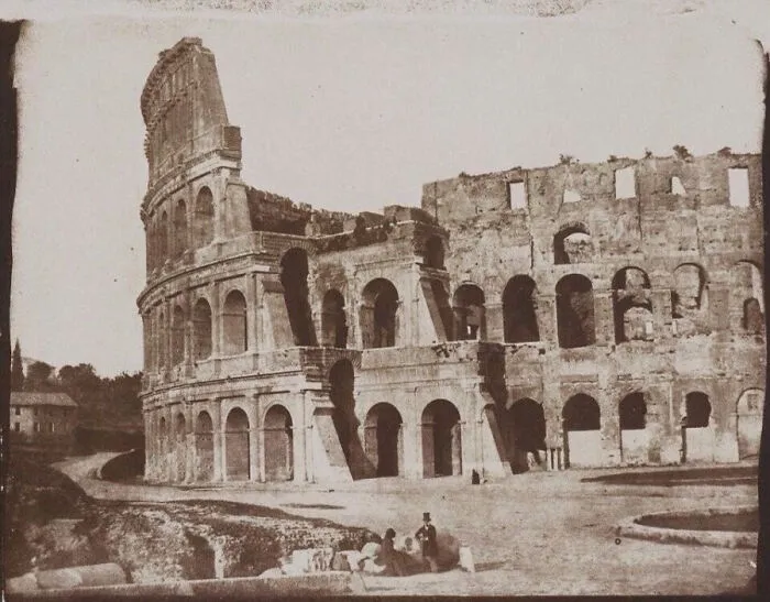 A historical photo of the Colosseum in Rome, showing its ancient ruins and preserving a piece of the past.