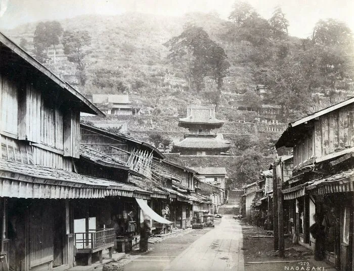 Historical photos: A street scene in Nagasaki with traditional buildings and a temple on a hillside, showing a past that will remain alive.