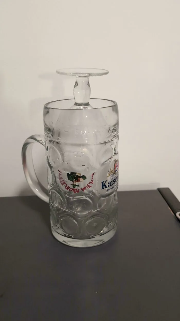 A large, clear beer stein with a smaller glass inverted and placed on its top, showcasing creative problem solving for fixing things.