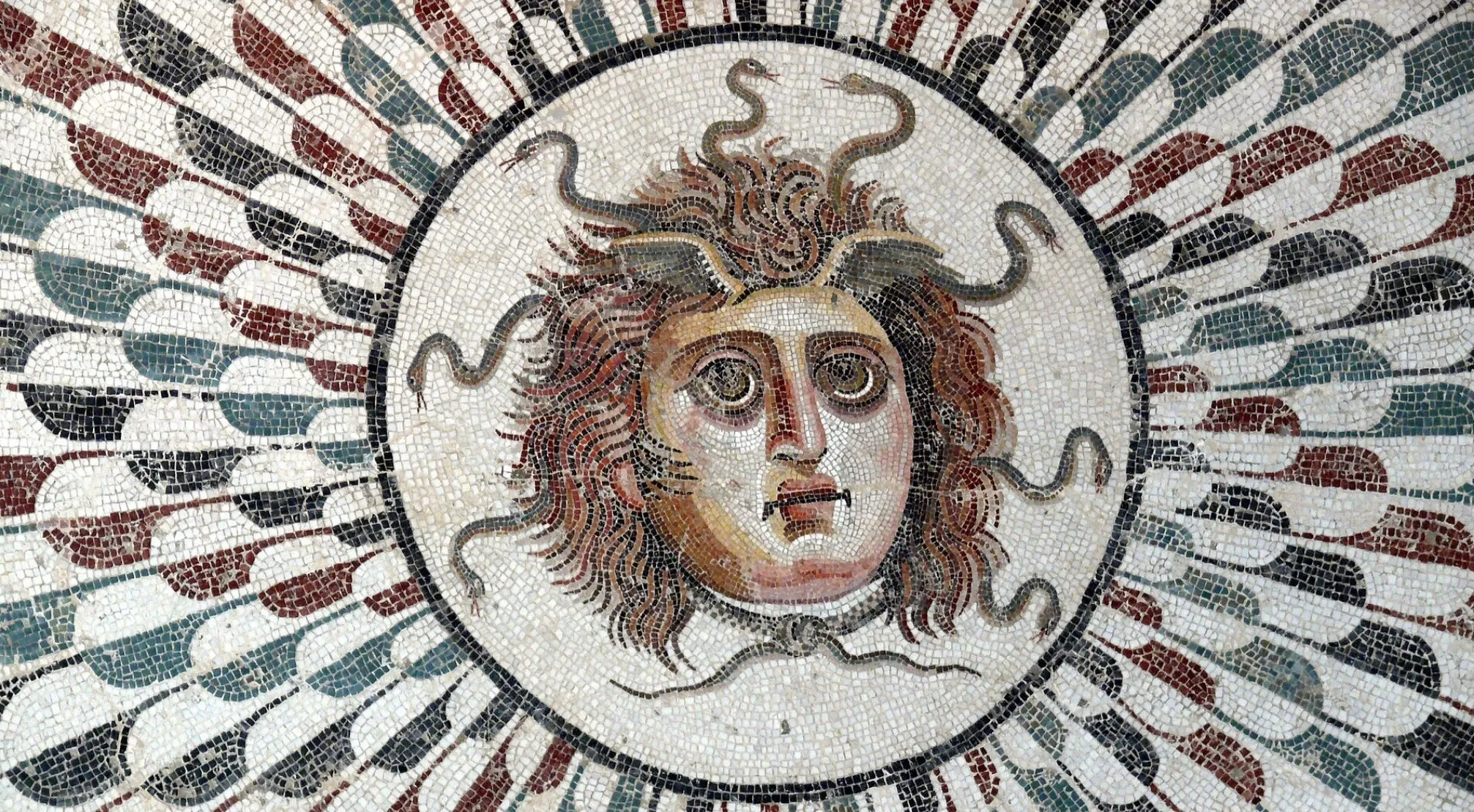 Mosaic art of Medusa's face with snakes for hair, illustrating Greek Mythology and the effect of Medusa's gaze.
