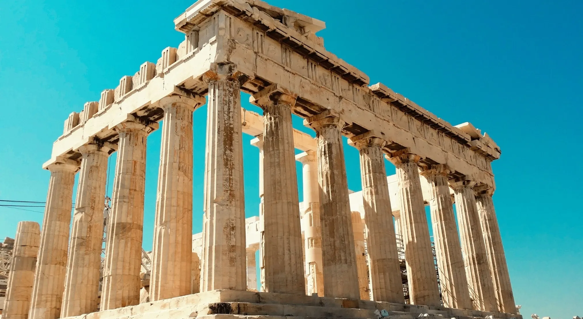 The majestic Parthenon against a clear blue sky, illustrating the home of the Greek gods in Greek Mythology.