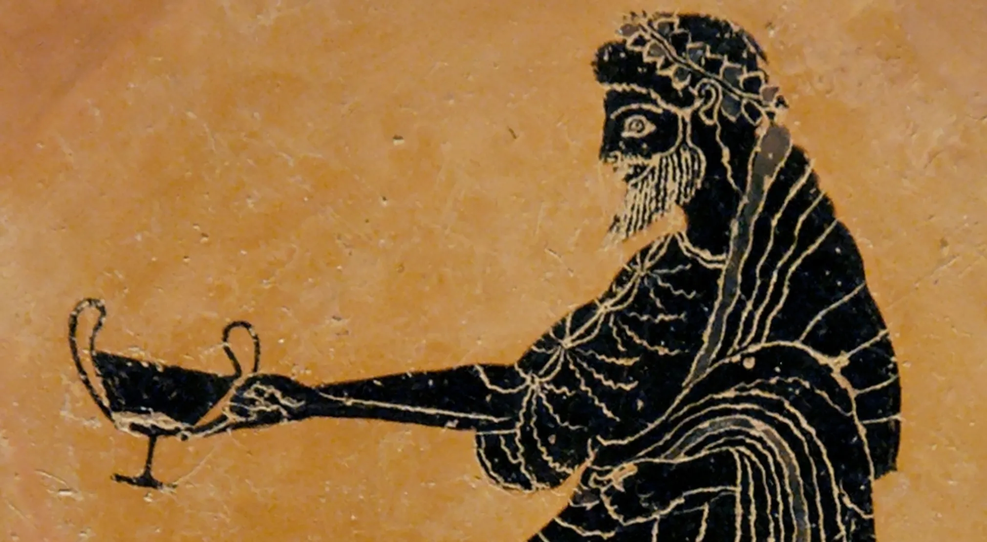 Ancient Greek pottery depicting a bearded figure, possibly Dionysus, holding a cup. Explore Greek Mythology.