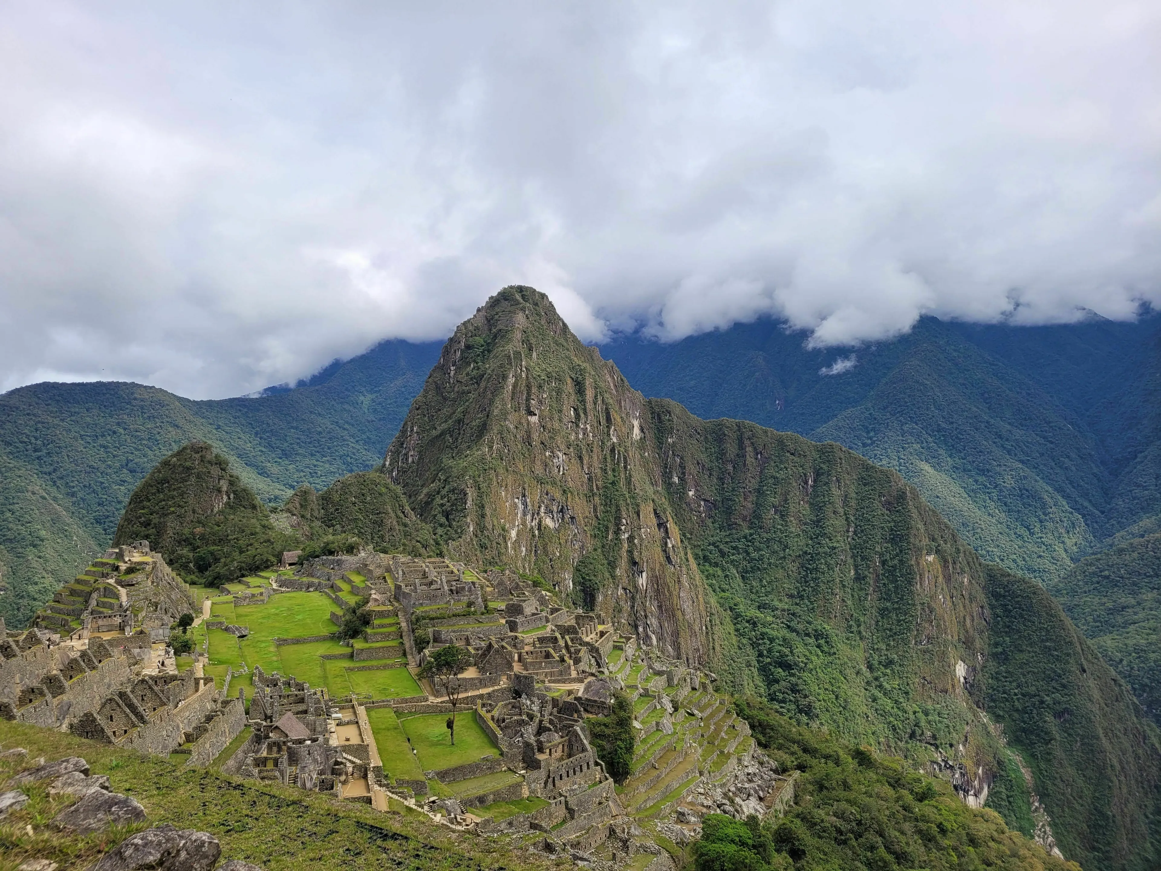 General knowledge quiz about the capital city of Peru, Machu Picchu in the Andes mountains under a cloudy sky.