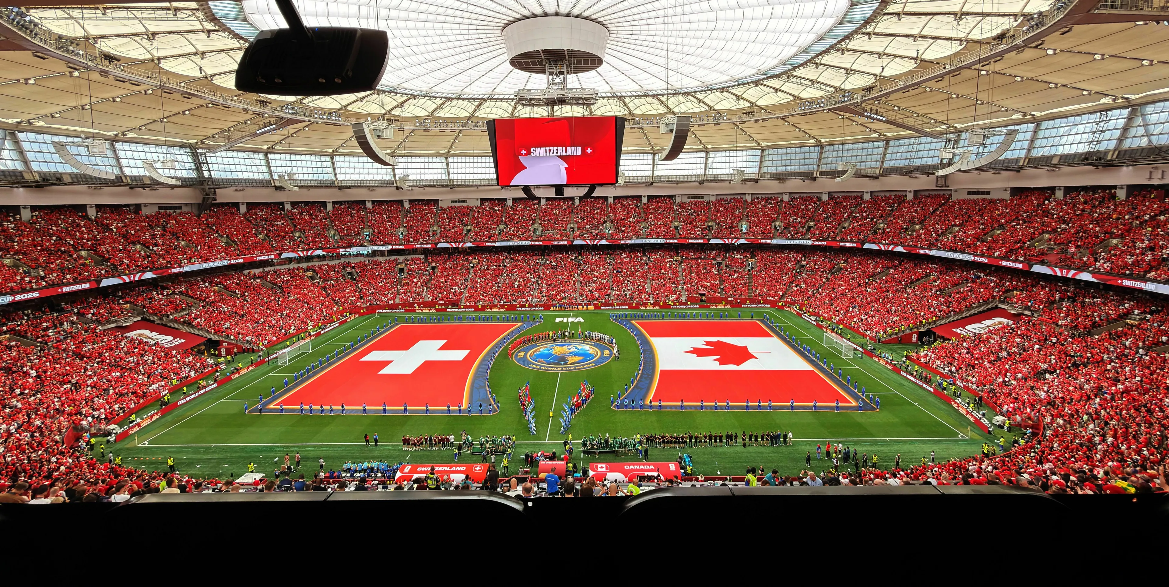 A packed stadium with Switzerland and Canada flags on the field, asking who won more men's FIFA World Cups. High IQ General Knowledge Test.
