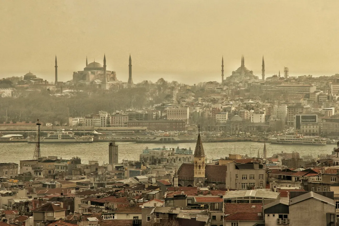 A scenic view of Constantinople, a capital city for four empires, featuring mosques and a river.