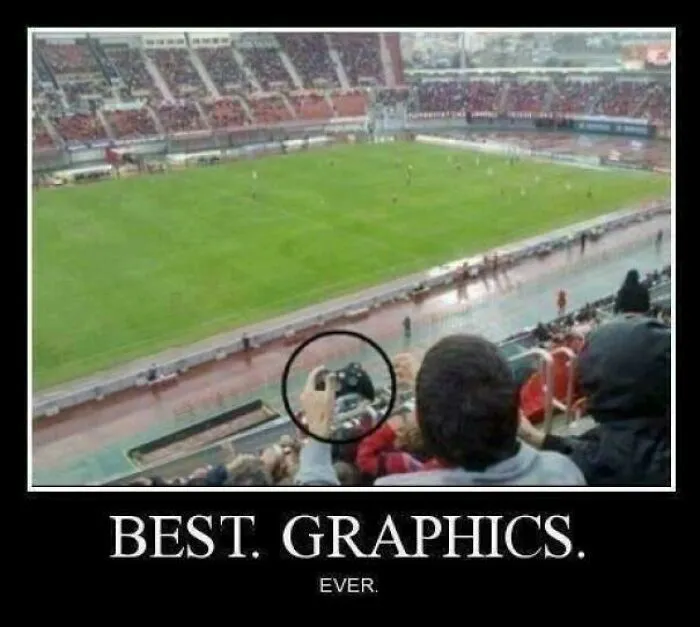 Humorous meme displaying a person at a real football match, holding a video game controller, captioned BEST. GRAPHICS. EVER.