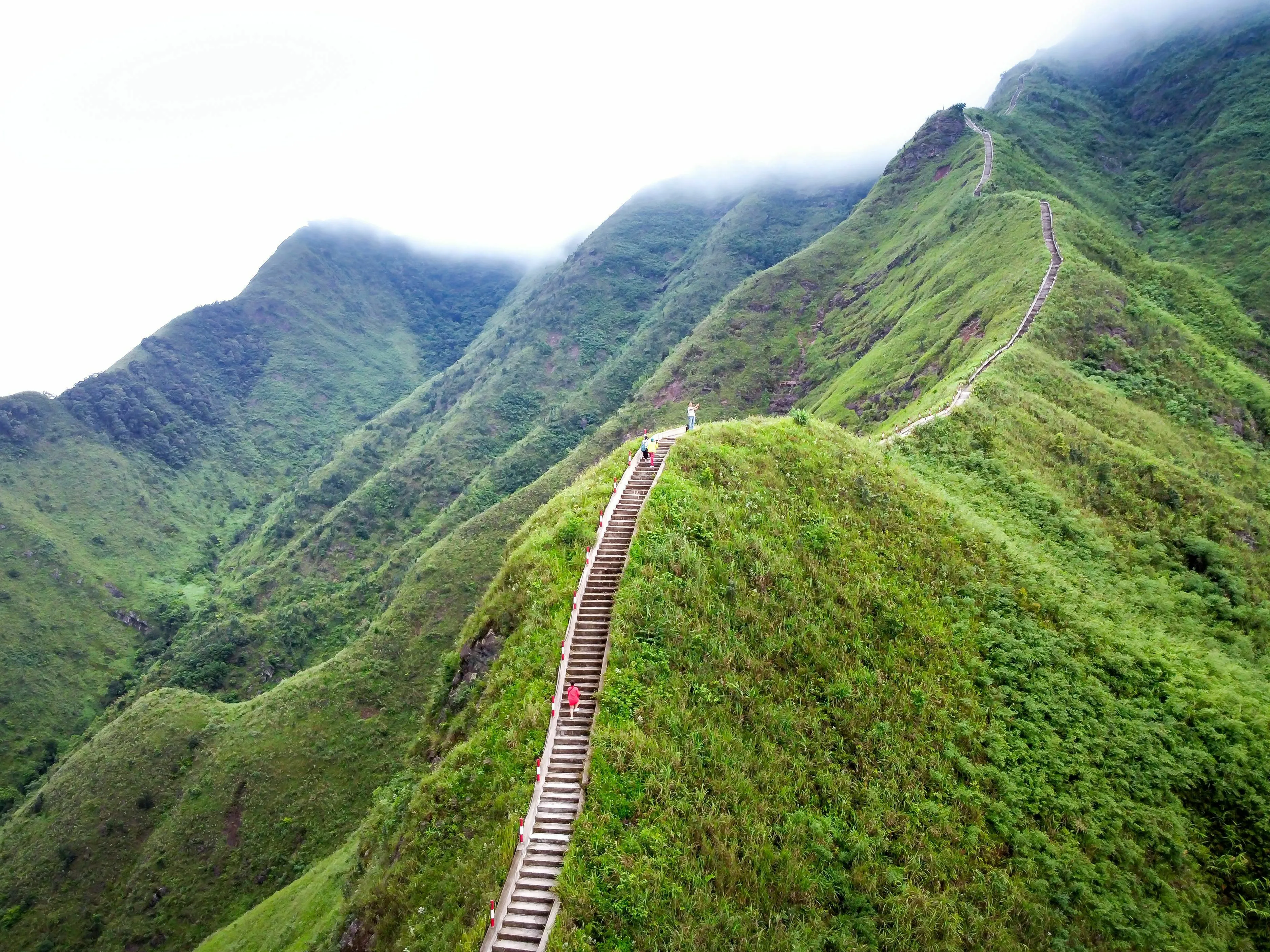 A long stairway leading up a lush green mountain, representing Stairway to Heaven, a classic rock song.