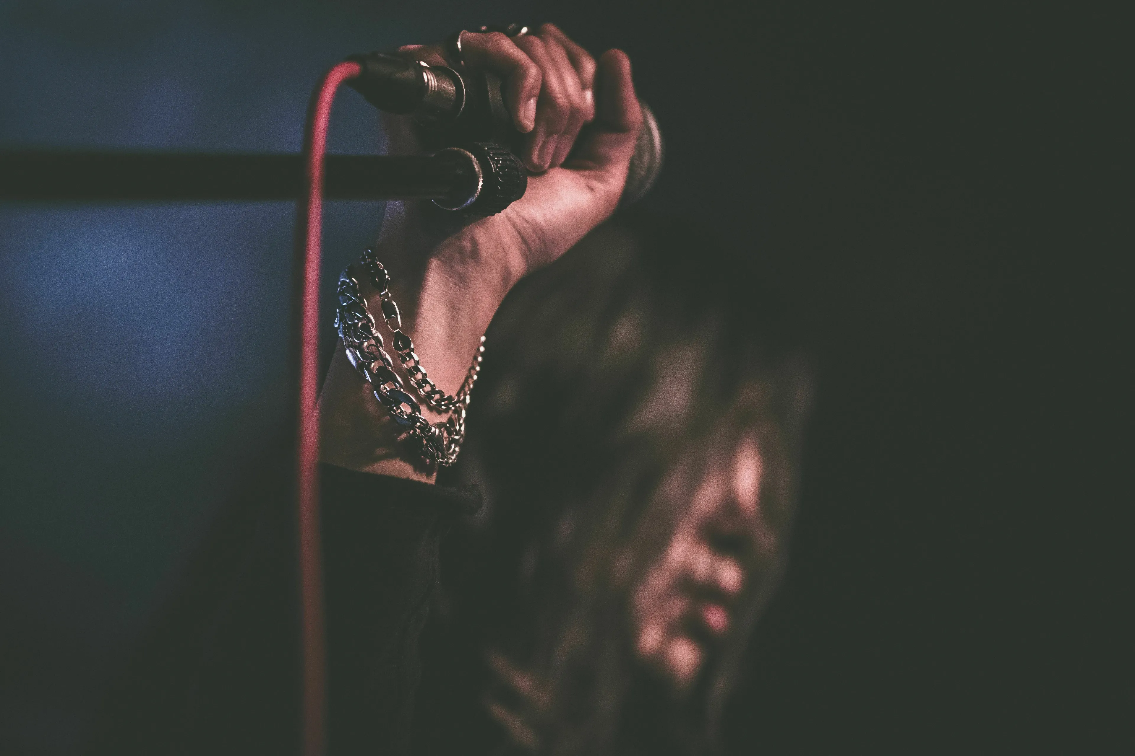 A-To-Z Music Quiz: Singer holding a microphone during a performance, with blurred background.