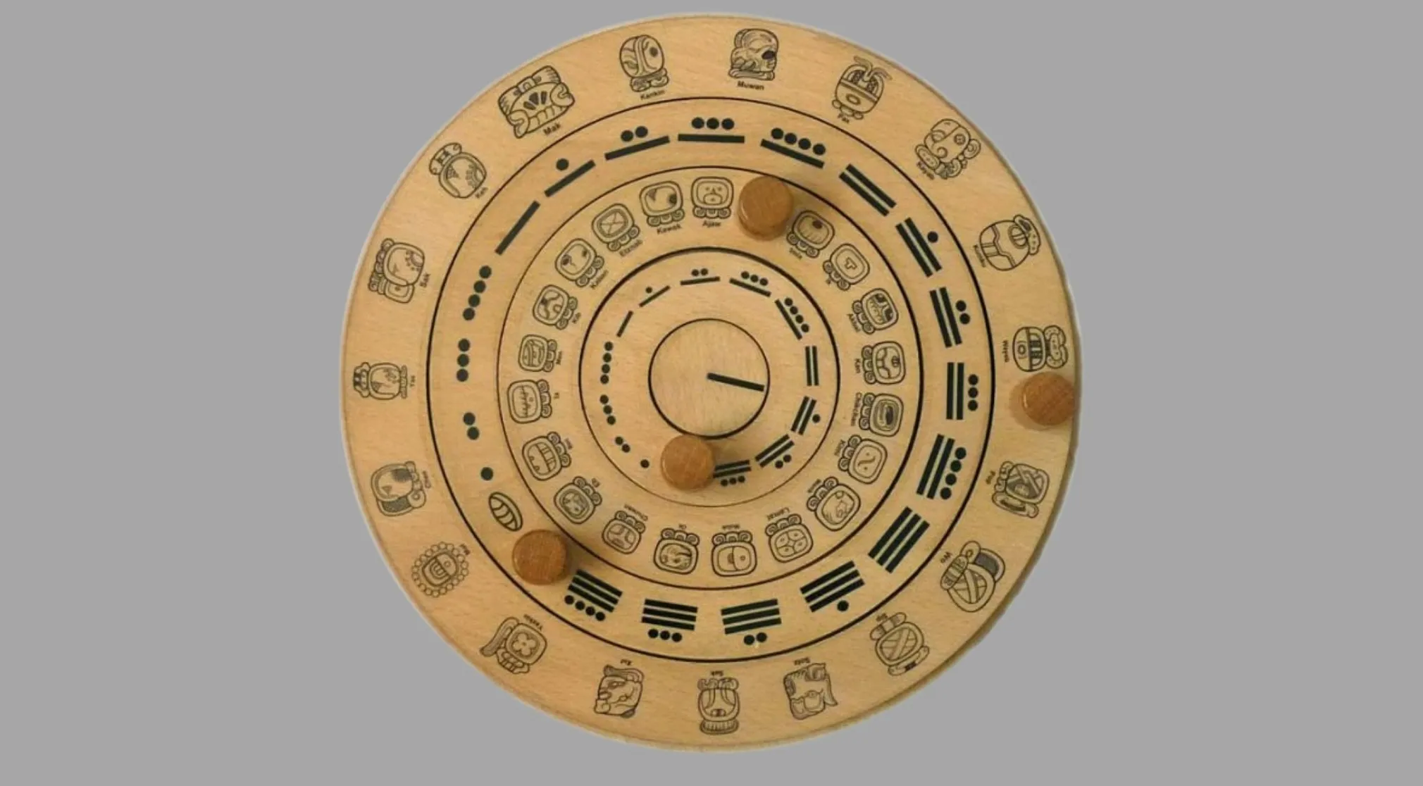 A circular wooden Mayan calendar with intricate carvings and three movable pegs. Ancient Civilizations.