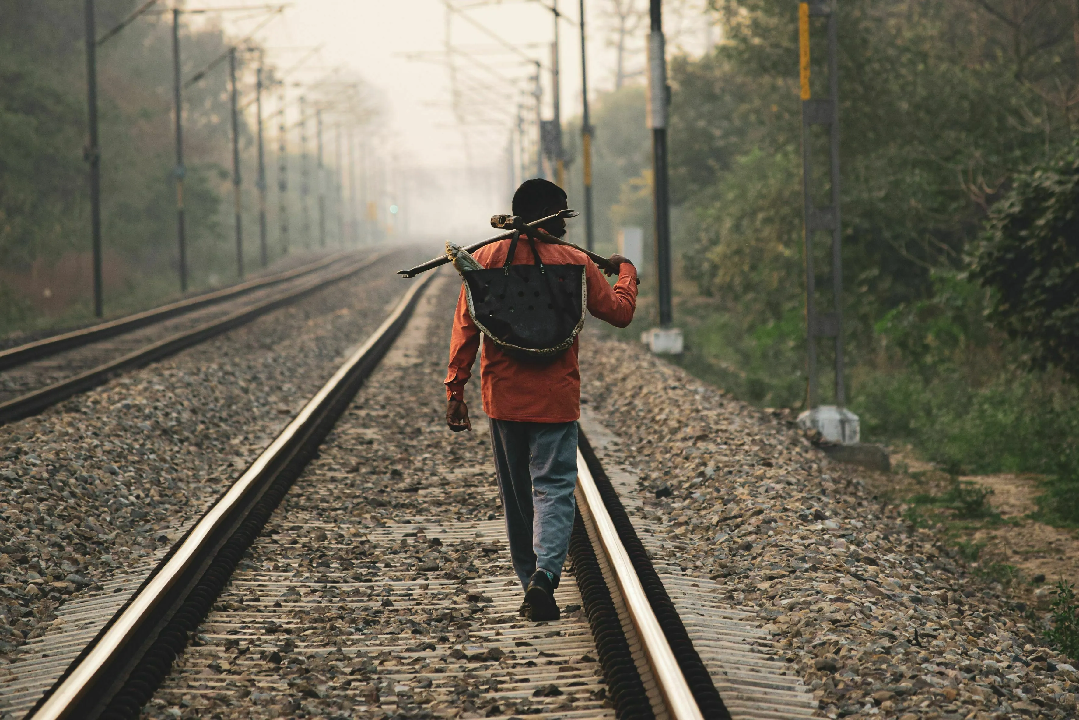 A lone traveler walks on train tracks, assembling a crew for a long journey and mythological quest.