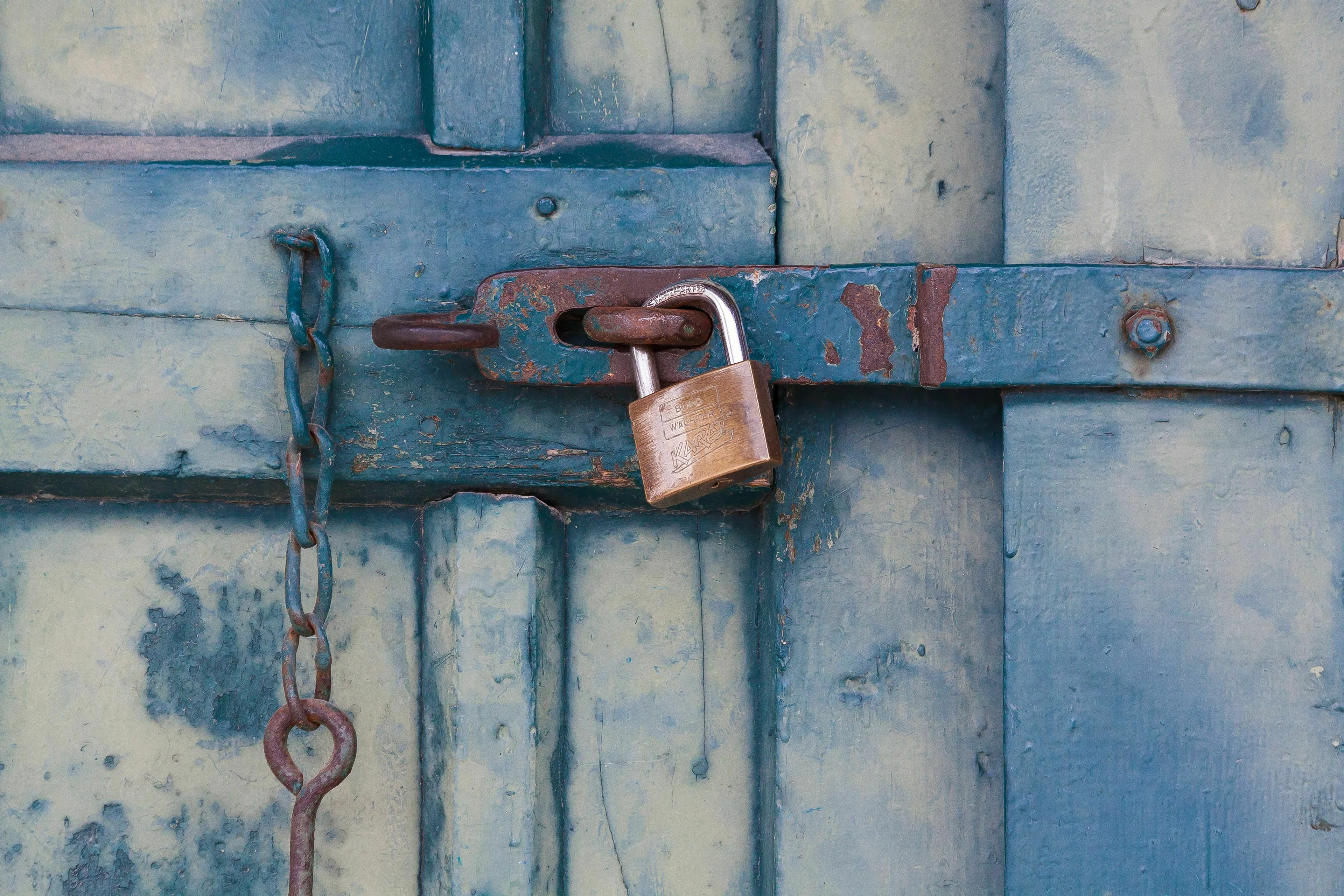 A locked door with a padlock, suggesting a mythological quest with a guarded riddle.