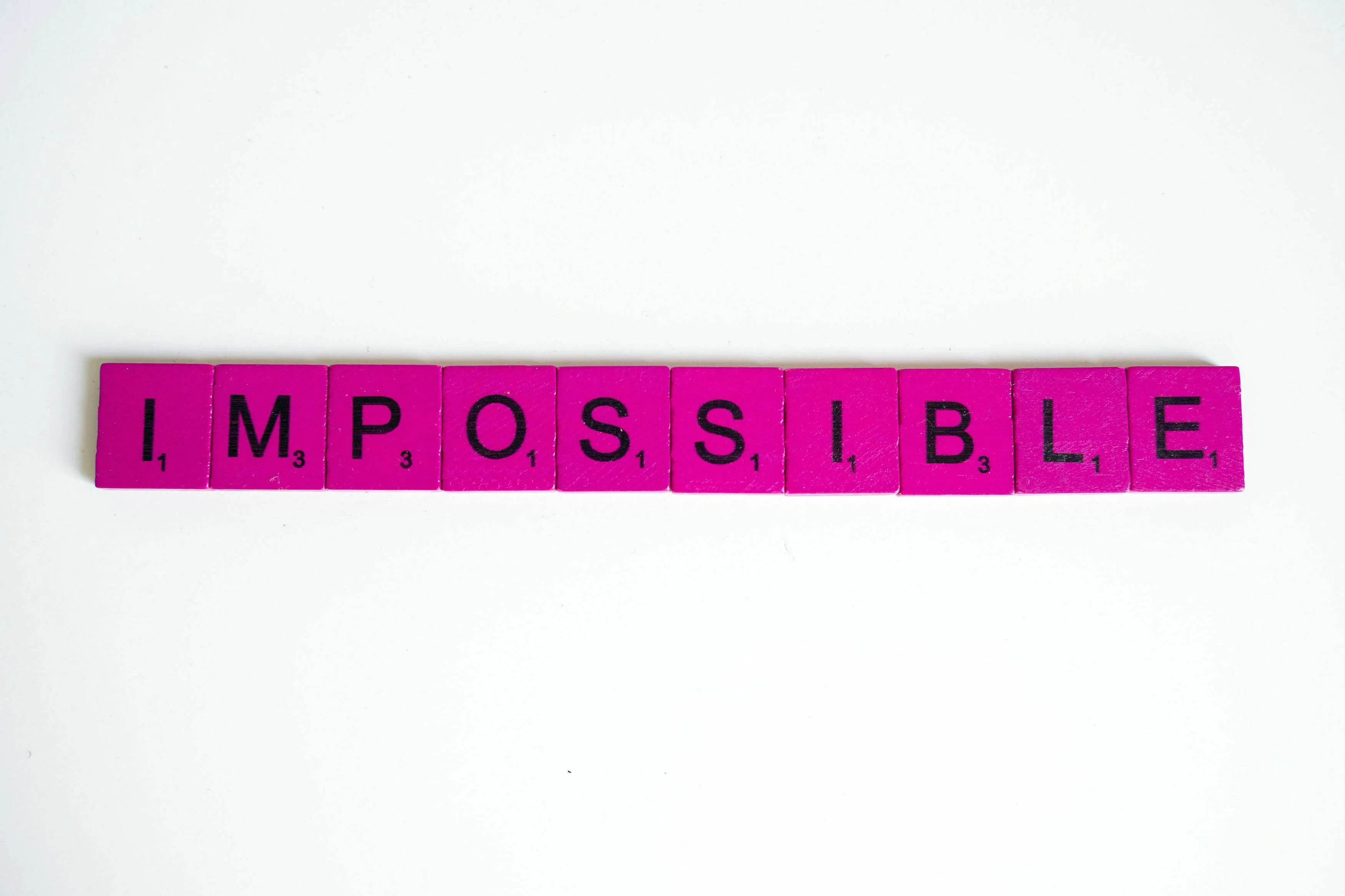 Pink Scrabble tiles spell IMPOSSIBLE. Which mythological quest would you be sent on?
