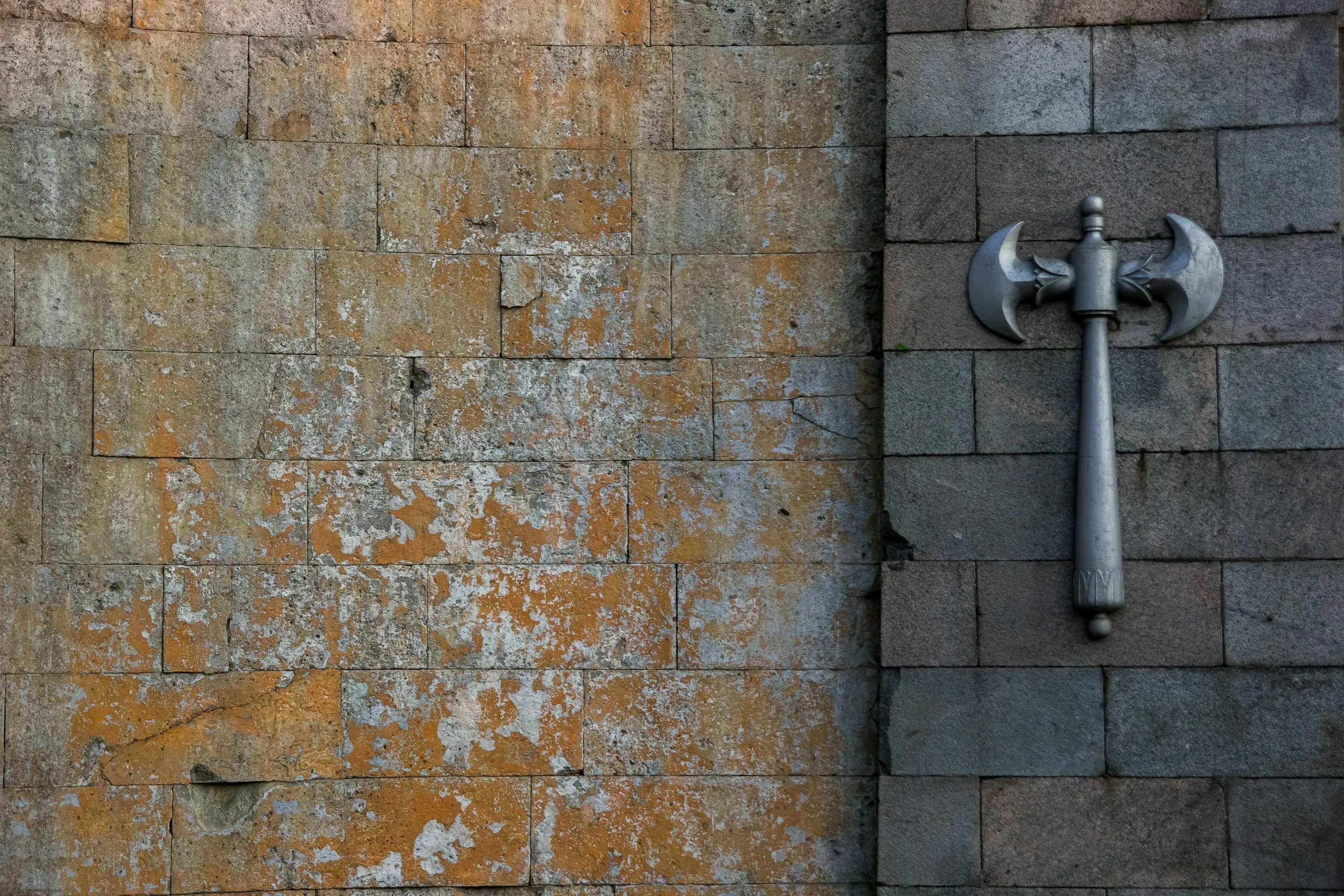 A double-bladed axe hangs on a stone wall. What's your backup plan for a mythological quest?