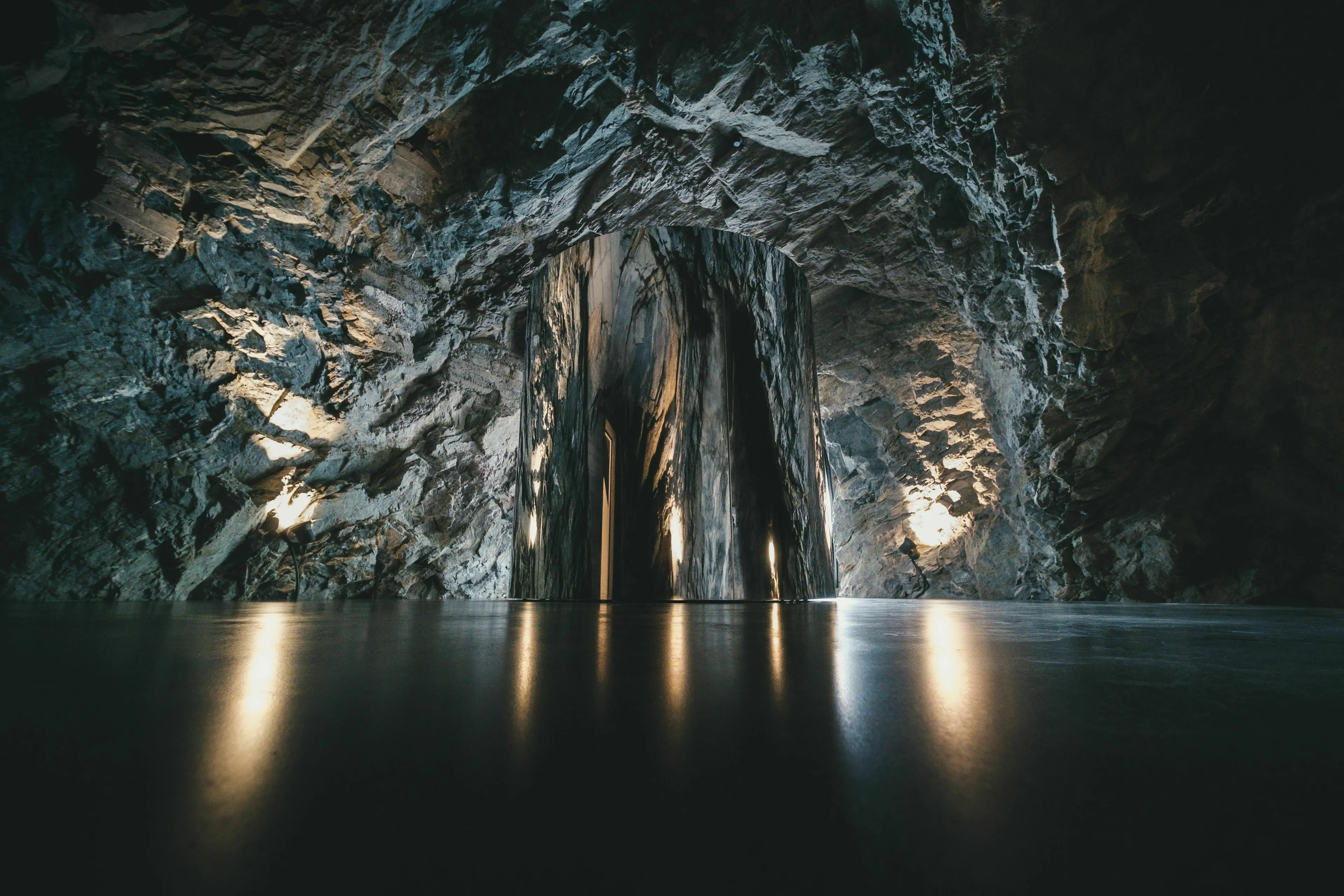 A glowing, futuristic structure in a dark, cavernous underworld, a mythological quest setting.