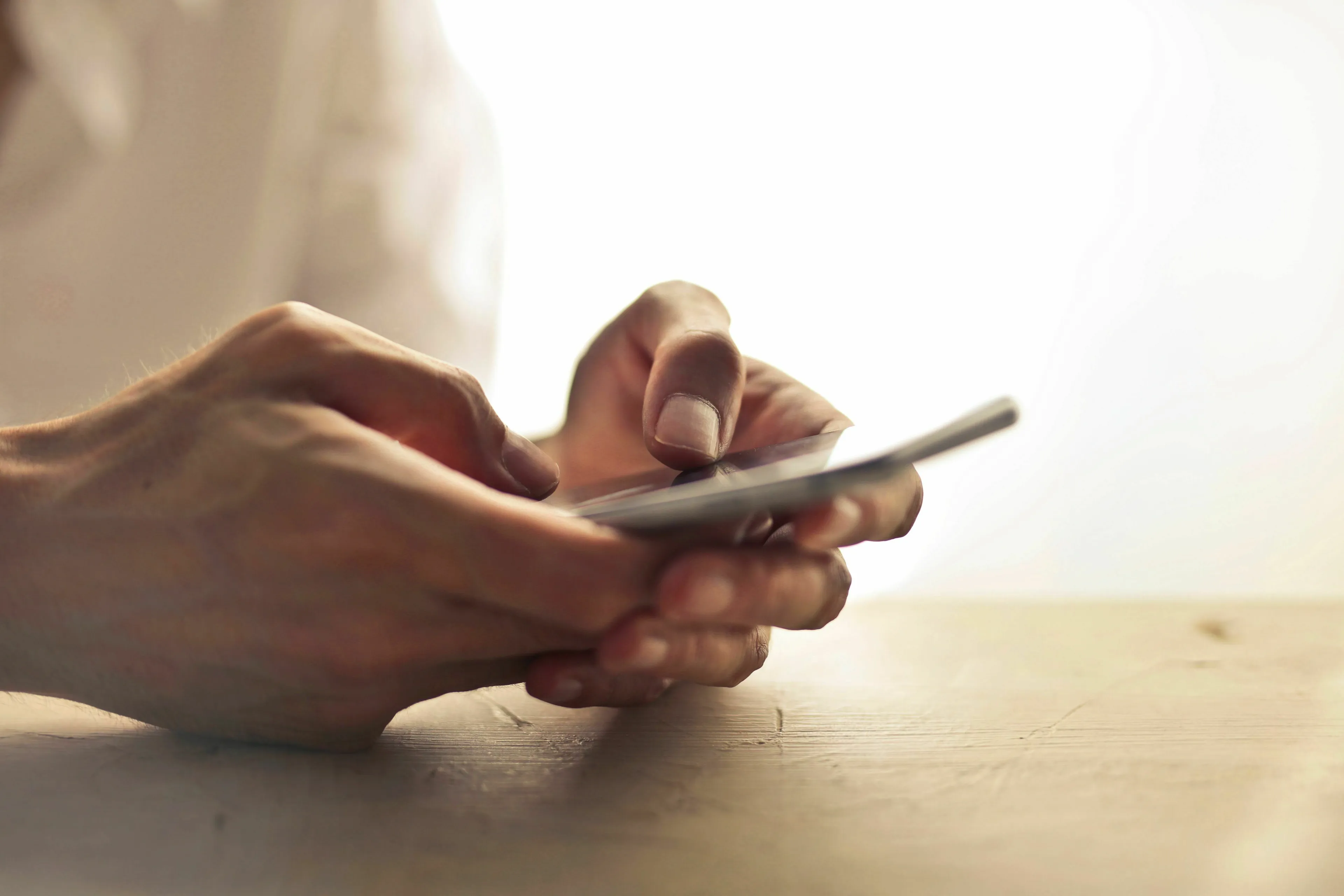 A person using a smartphone to text, considering their first move in a conversation about green flags.