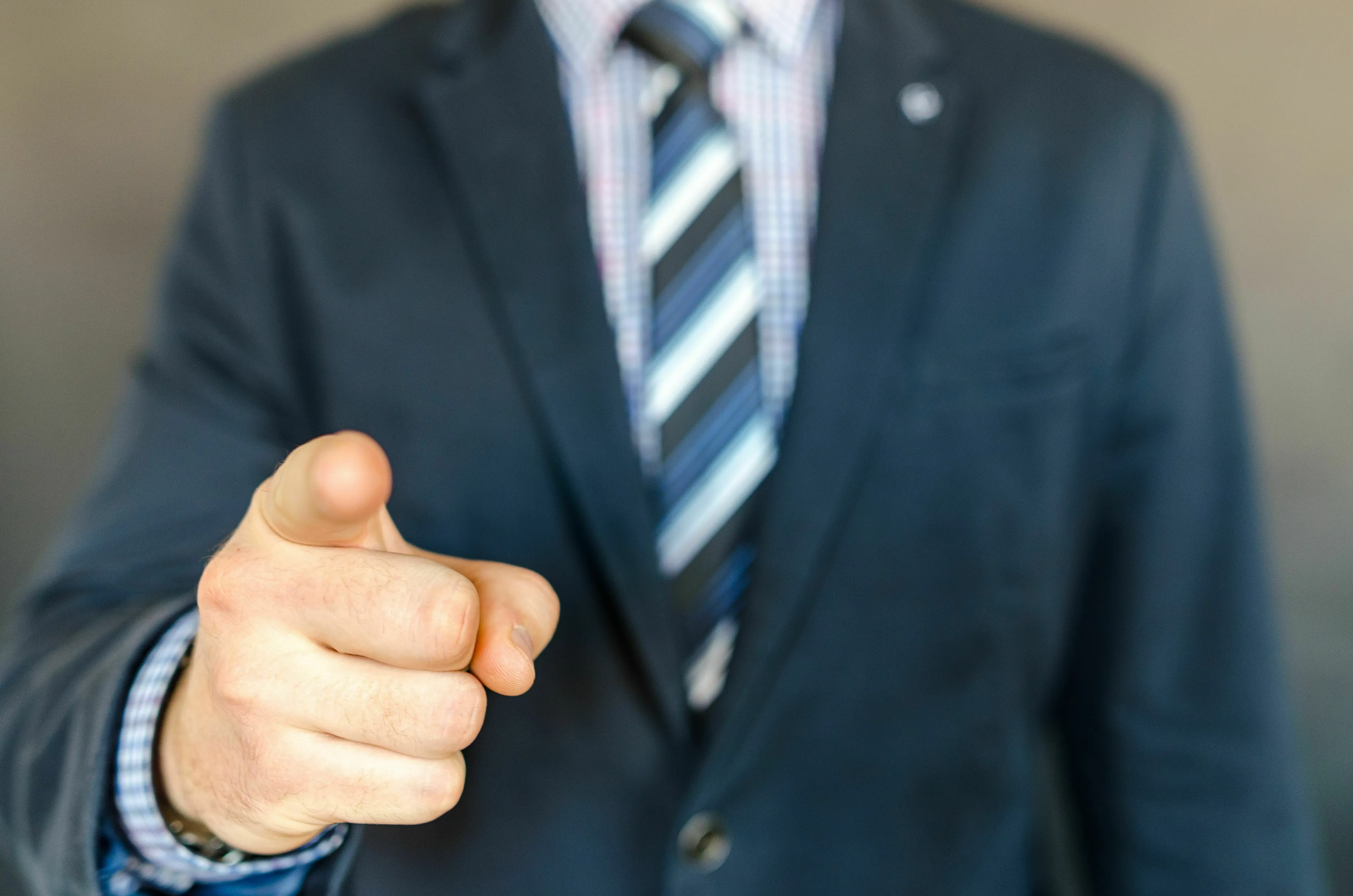 A person in a suit pointing, what people come to you for, a green flag.