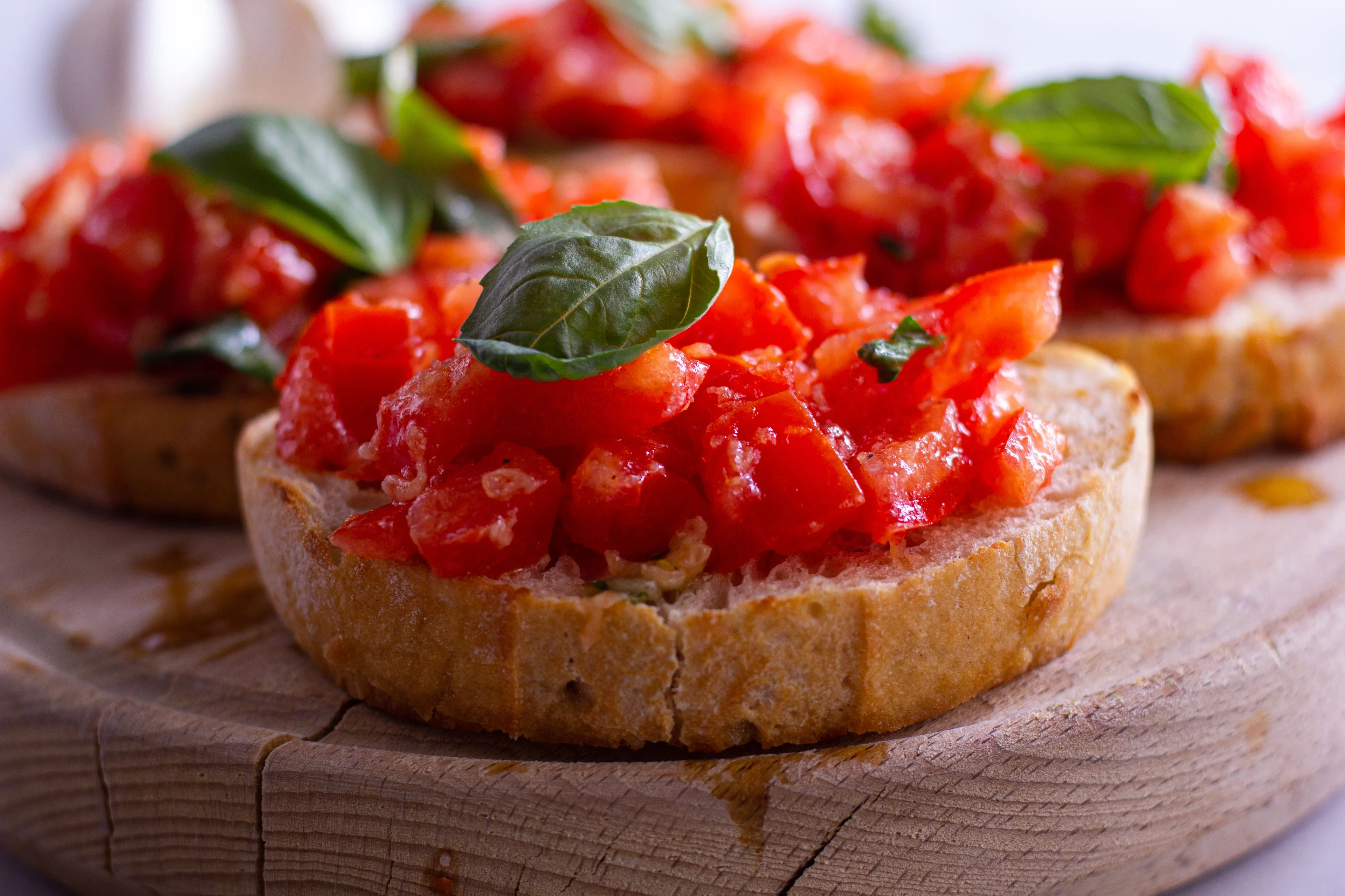 Delicious bruschetta topped with fresh chopped tomatoes and basil, presented on a rustic wooden cutting board.