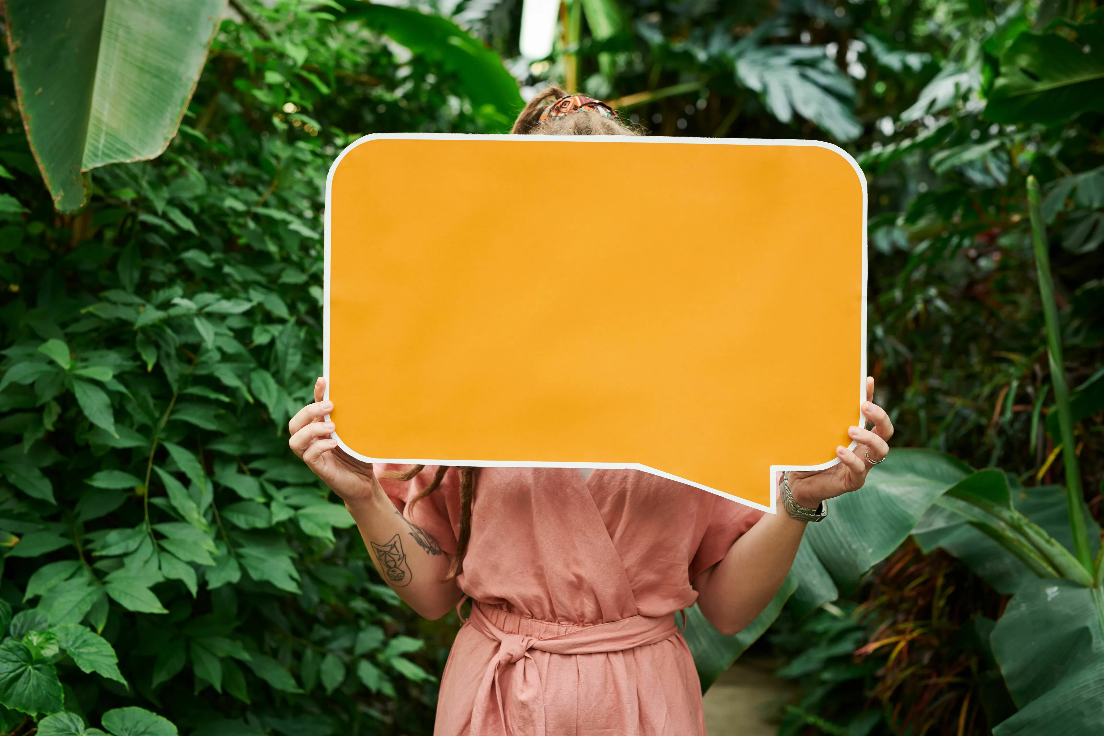 A person holding an orange speech bubble, representing different languages in the world.