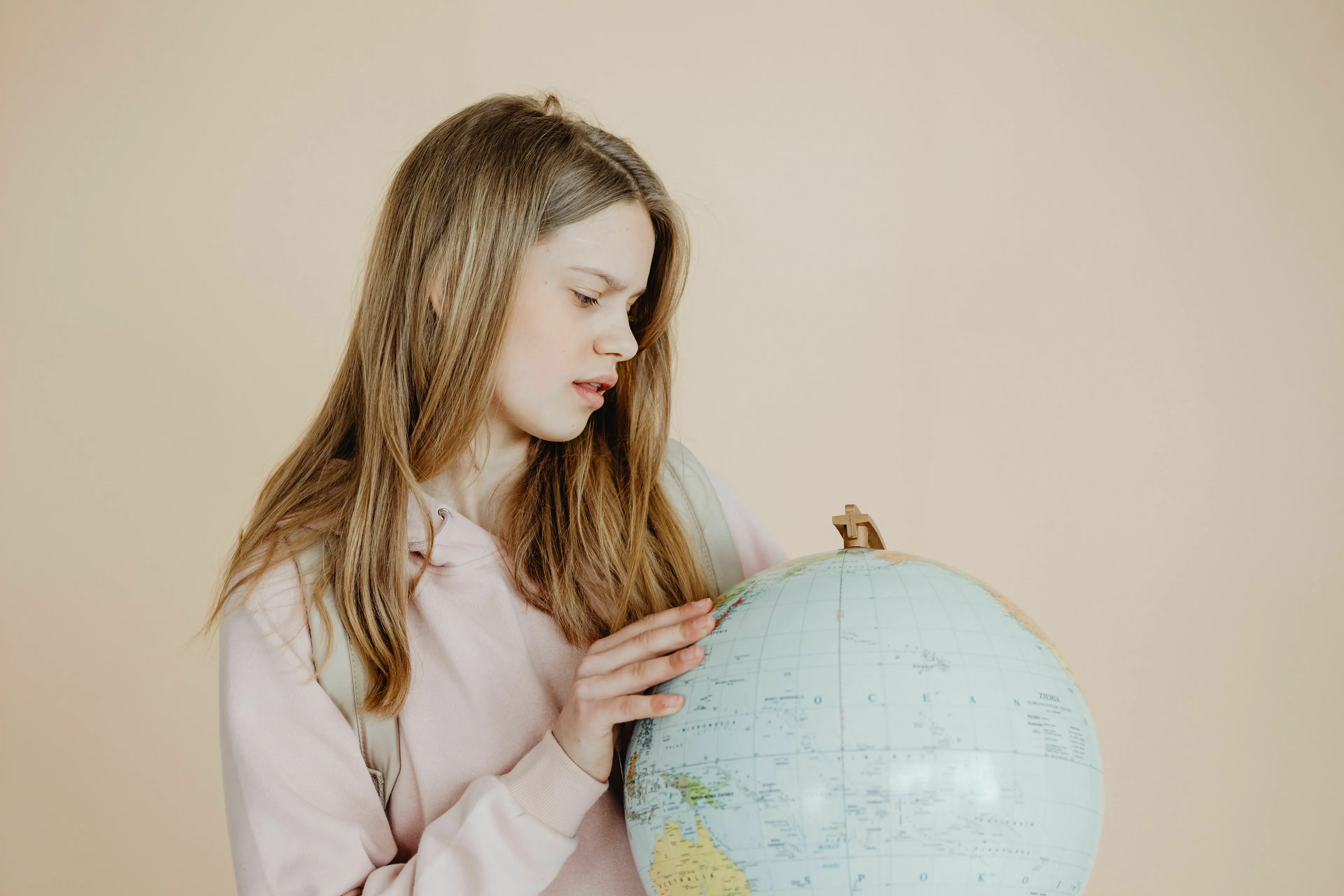 A young person looking intently at a globe, exploring general knowledge about continents like South America.