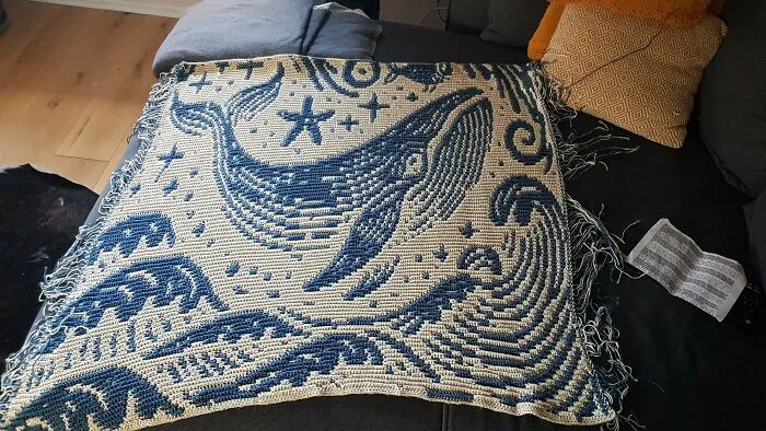 Blue and white crochet blanket featuring a large whale and starfish design