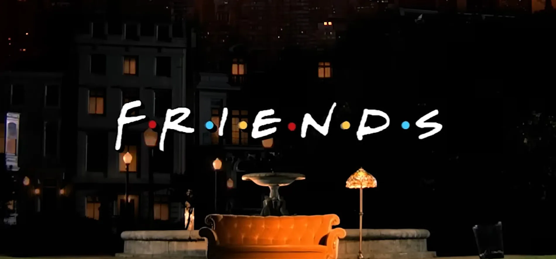 The Friends TV show logo in front of a fountain and an orange couch at night.
