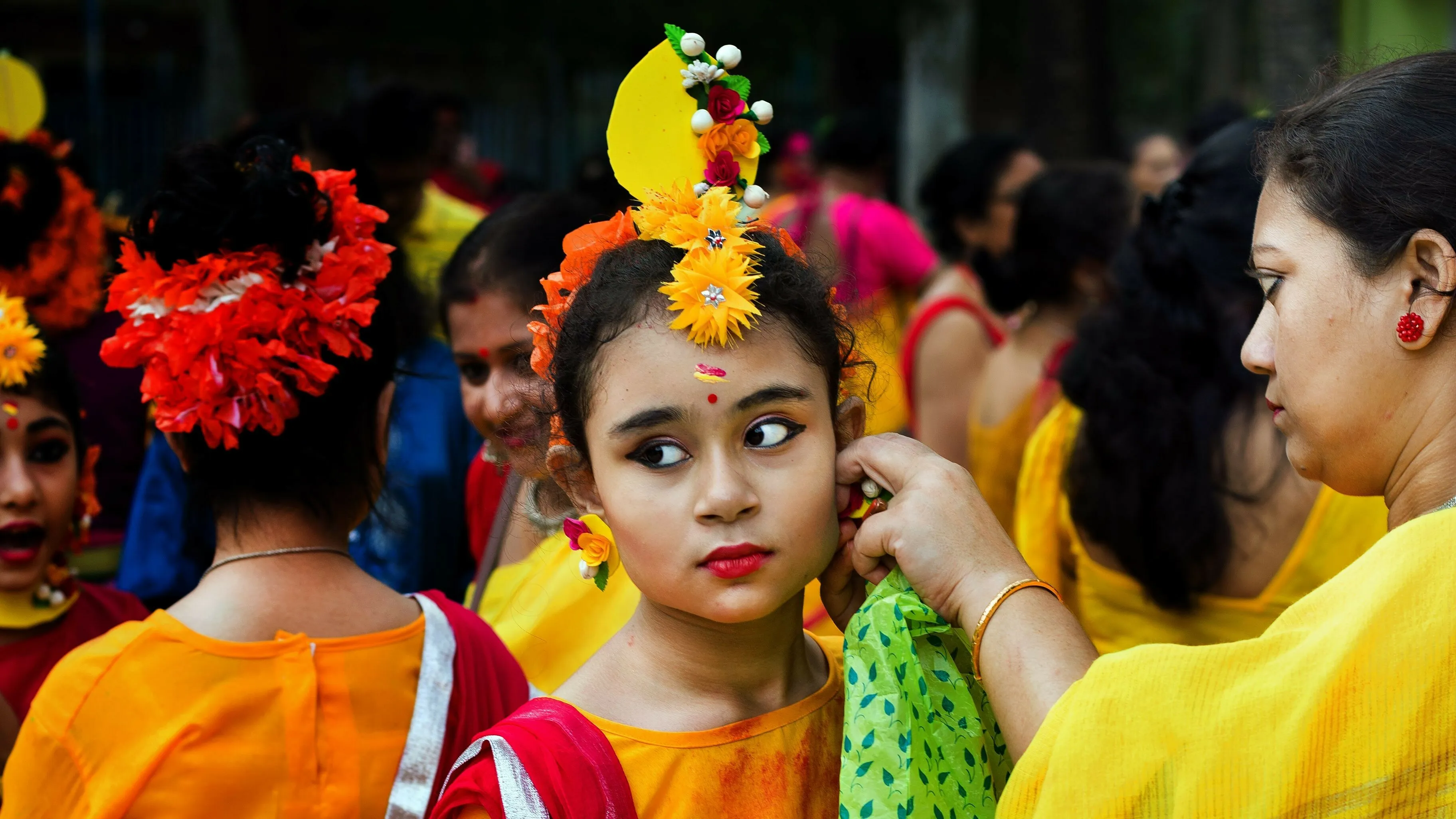 Young girl in traditional attire with floral decorations, representing the colors of India's flag.