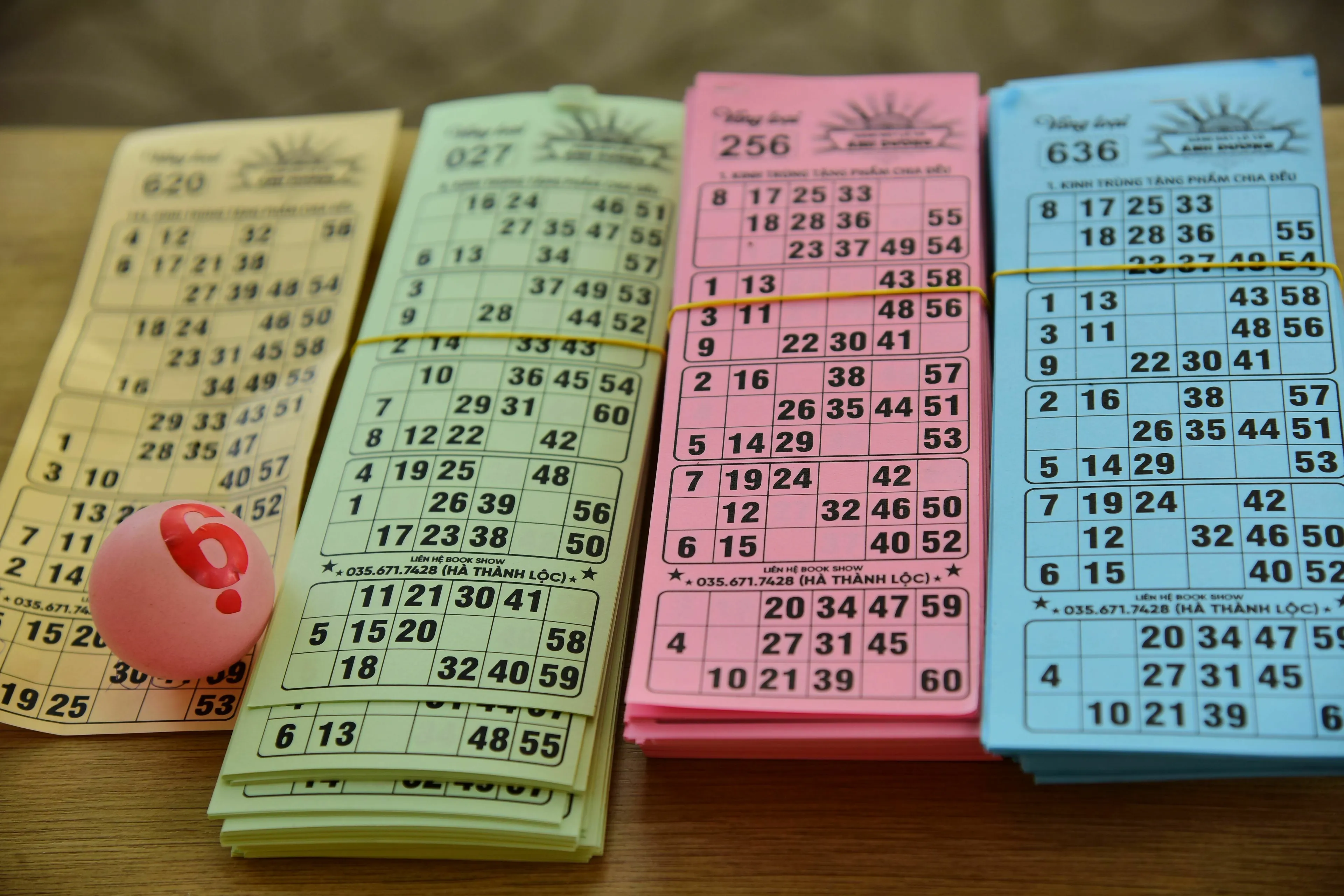 Colorful lottery tickets and a question mark ball, representing the worries if a lottery win goes public and triggers envy.