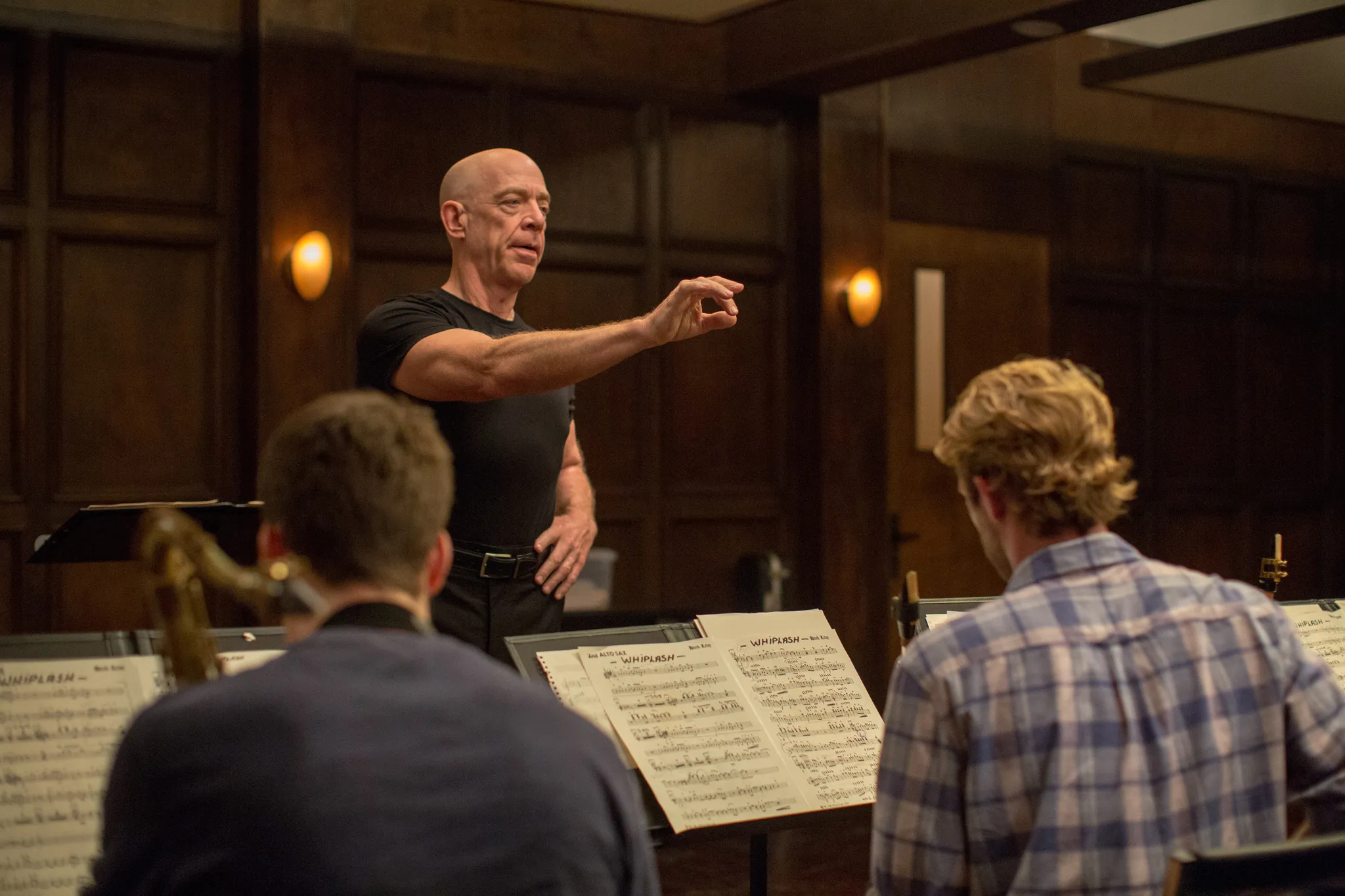 A intense scene from Whiplash, featuring a demanding conductor and a drummer during a music session on a lazy Sunday.