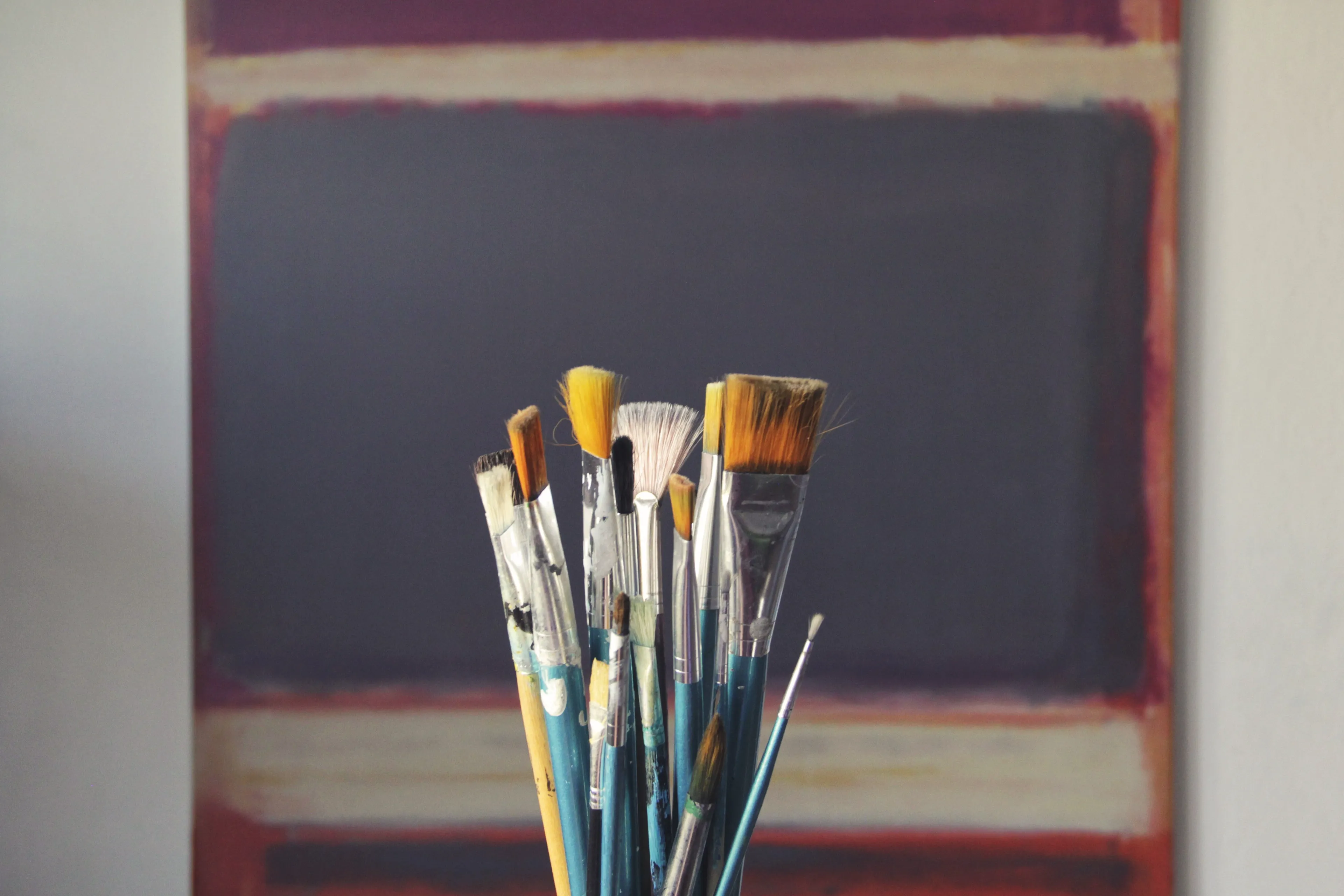 Art brushes in front of a painting, symbolizing the school subject Art and a competitive streak.