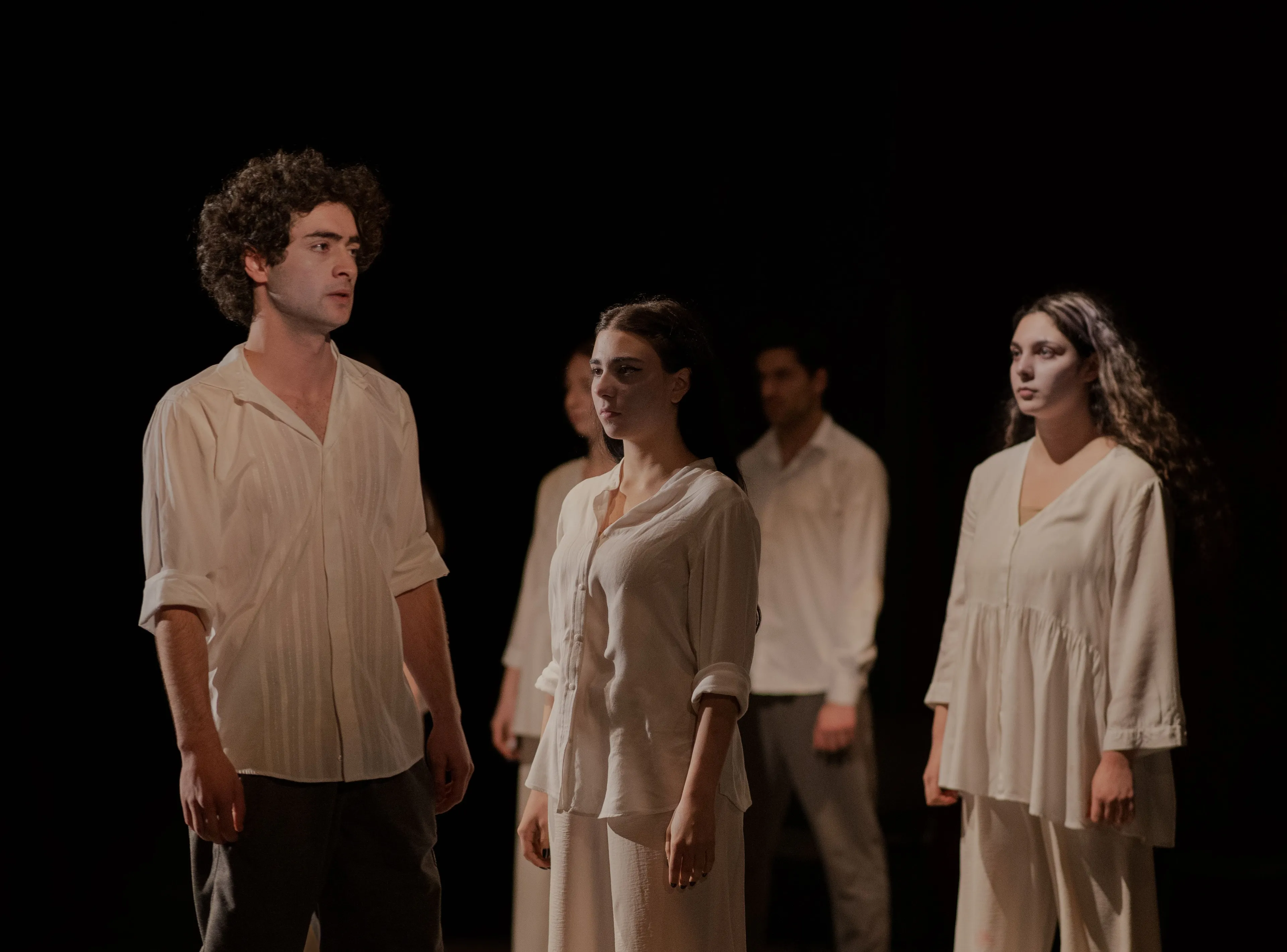 Competitive streak in Drama, with actors on stage in white, expressive clothing under spotlights, conveying dramatic emotion.